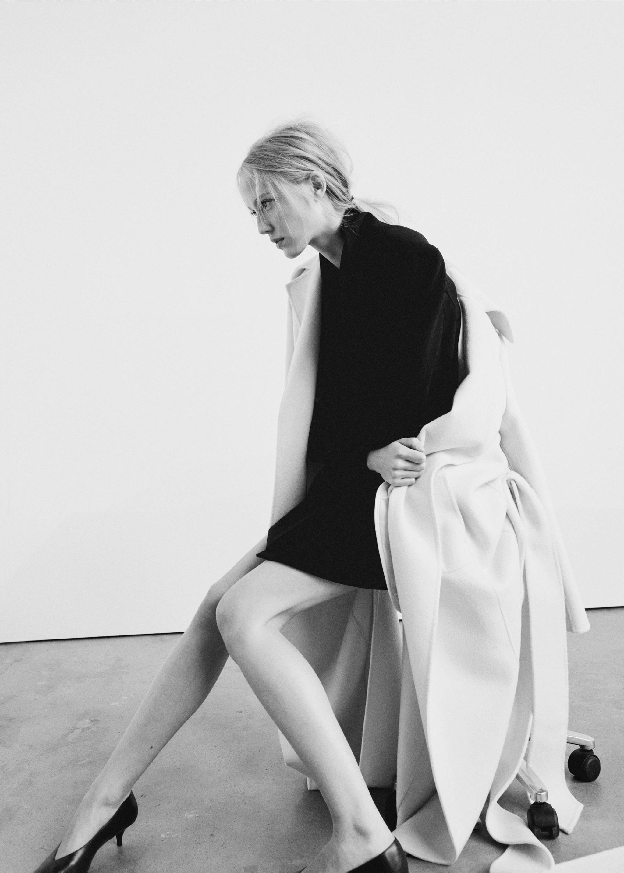 Black dress worn with a light-coloured coat on a seated model., Black. Ref: 37077784-00.