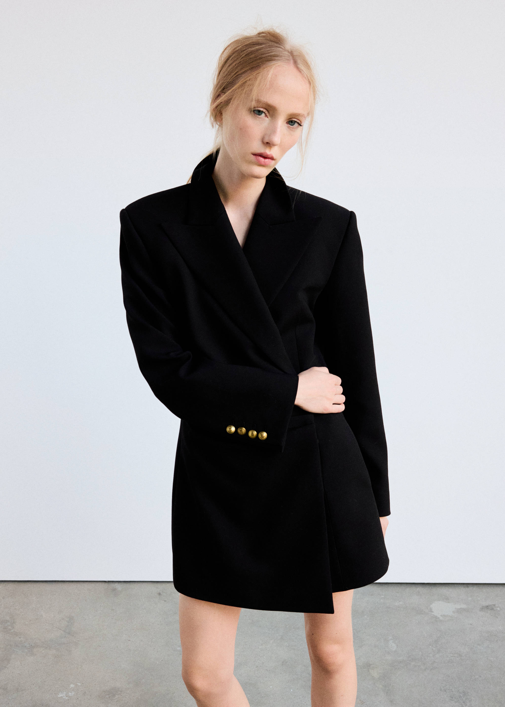 Black tailored blazer dress with lapel collar and gold-toned cuff buttons.