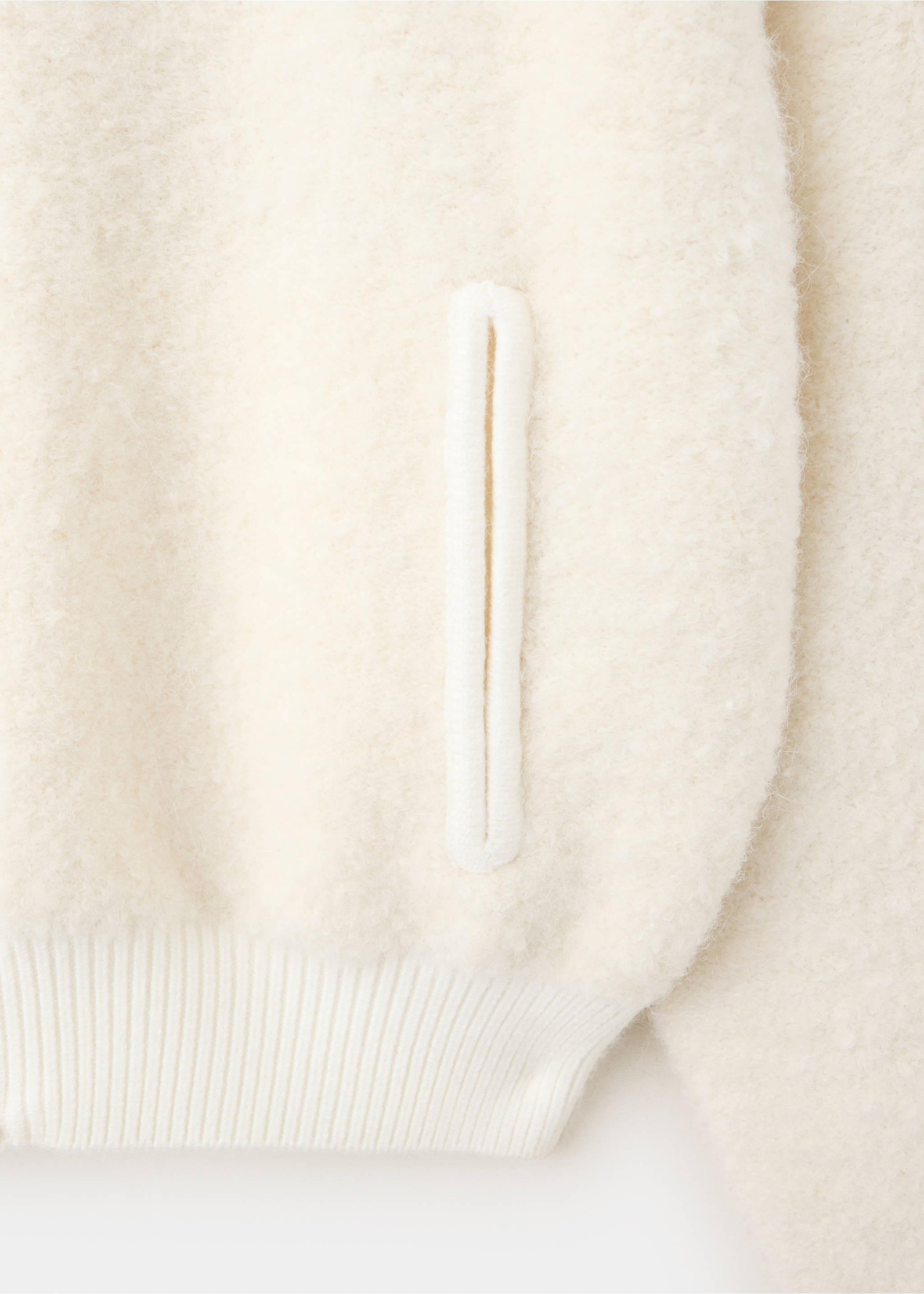 Close-up of an off-white textured jacket showing a vertical welt pocket., Ecru. Ref: 37077785-00.