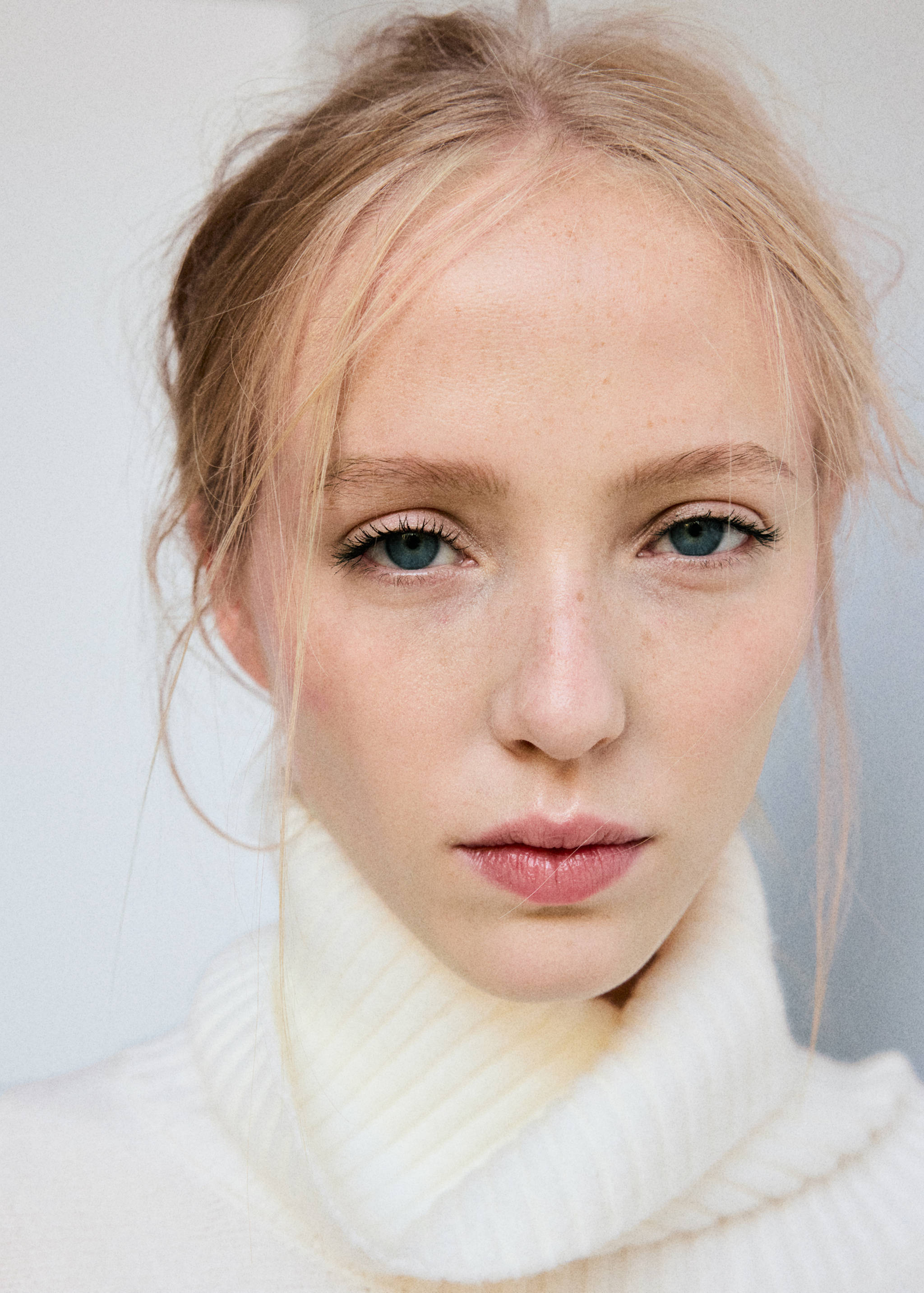 Close-up of a white high-neck ribbed cape.