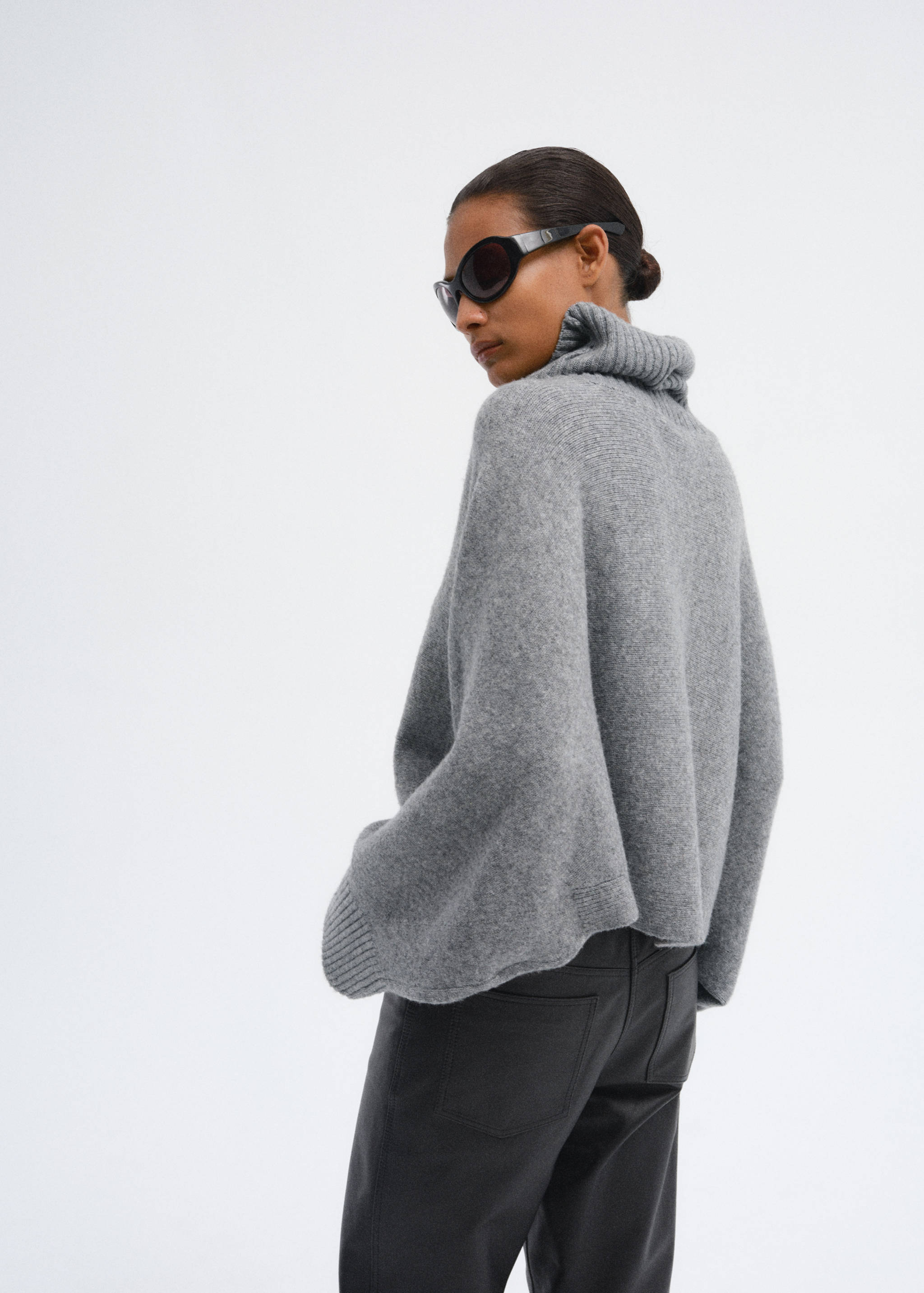 Grey knit cape with a ribbed turtleneck, back view.