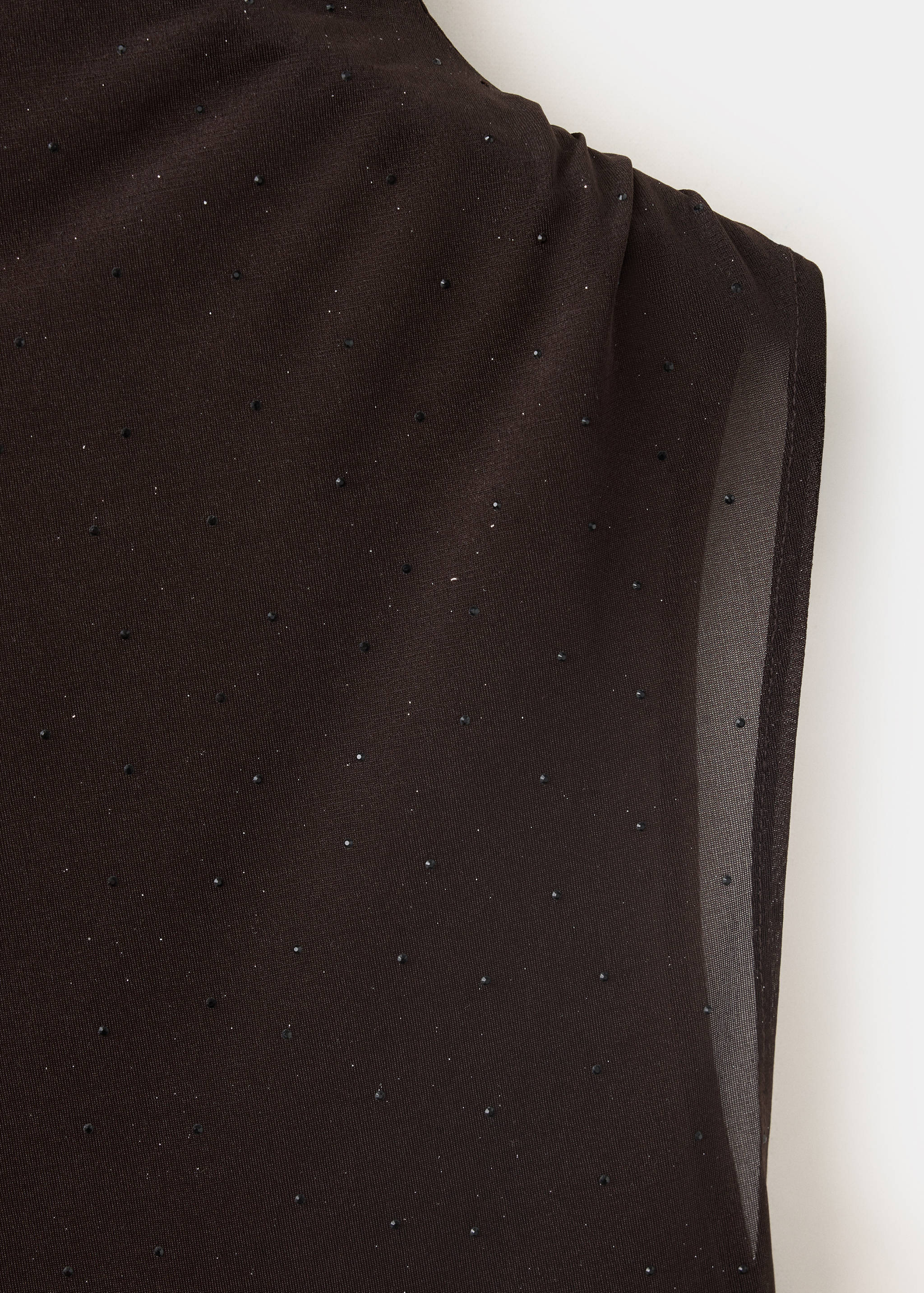Close-up of a black sleeveless top with tonal rhinestones.