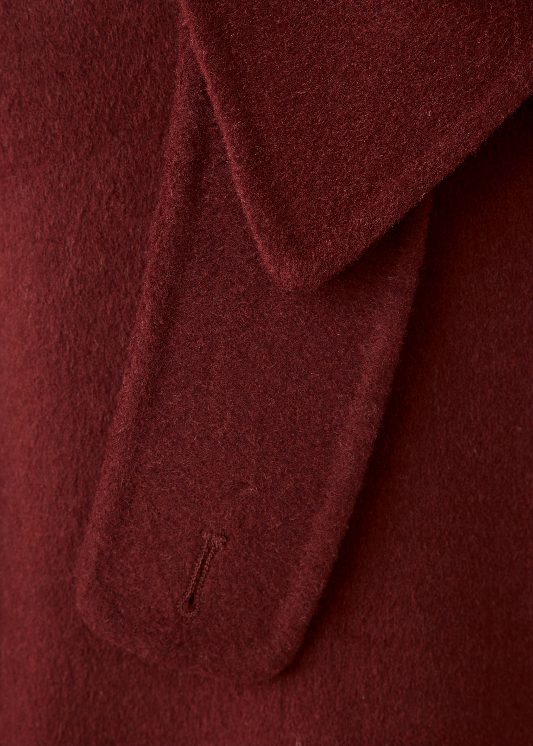 Close-up of a dark burgundy jacket lapel and button tab., Red. Ref: 37077795-00.