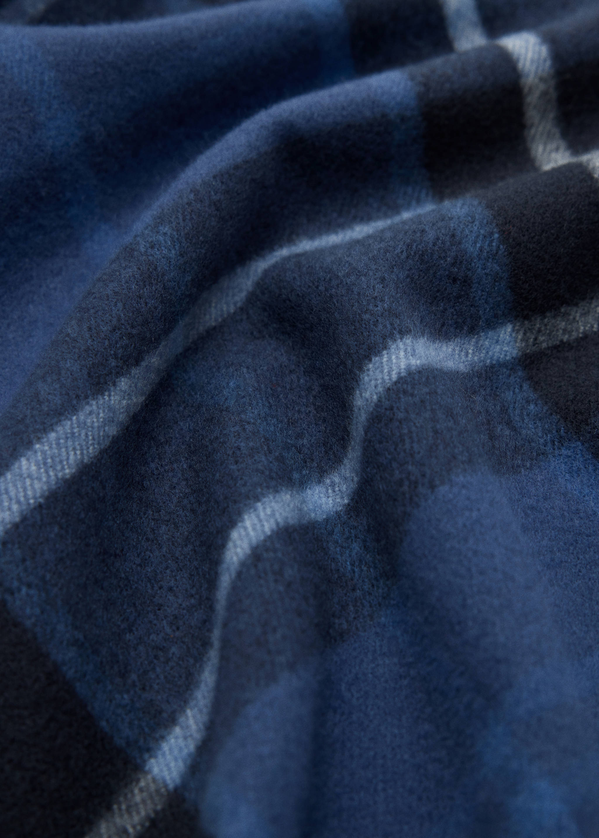 Blue check scarf in a soft-texture fabric close-up.