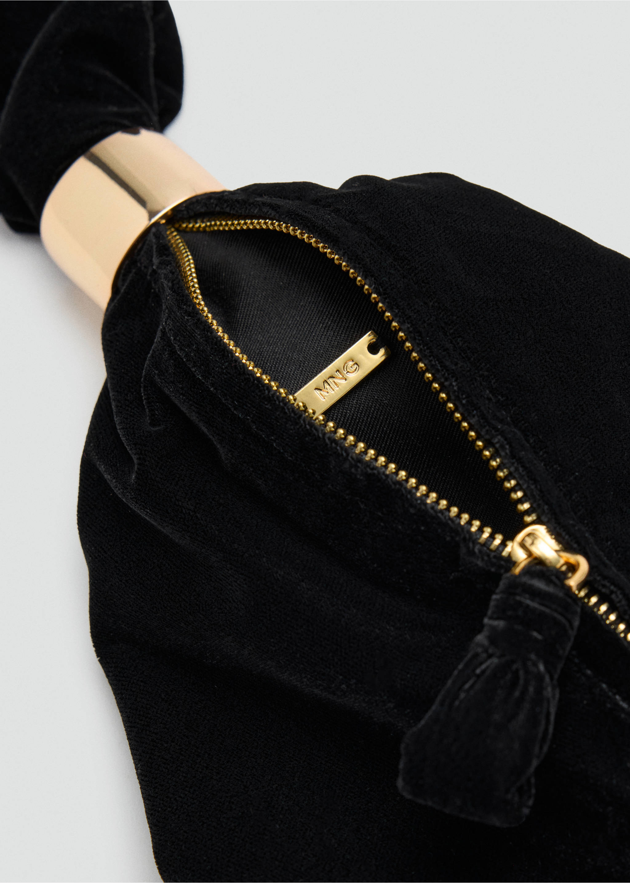 Close-up of a black velvet handbag zipper and gold metal ring detail., Black. Ref: 37077805-00.