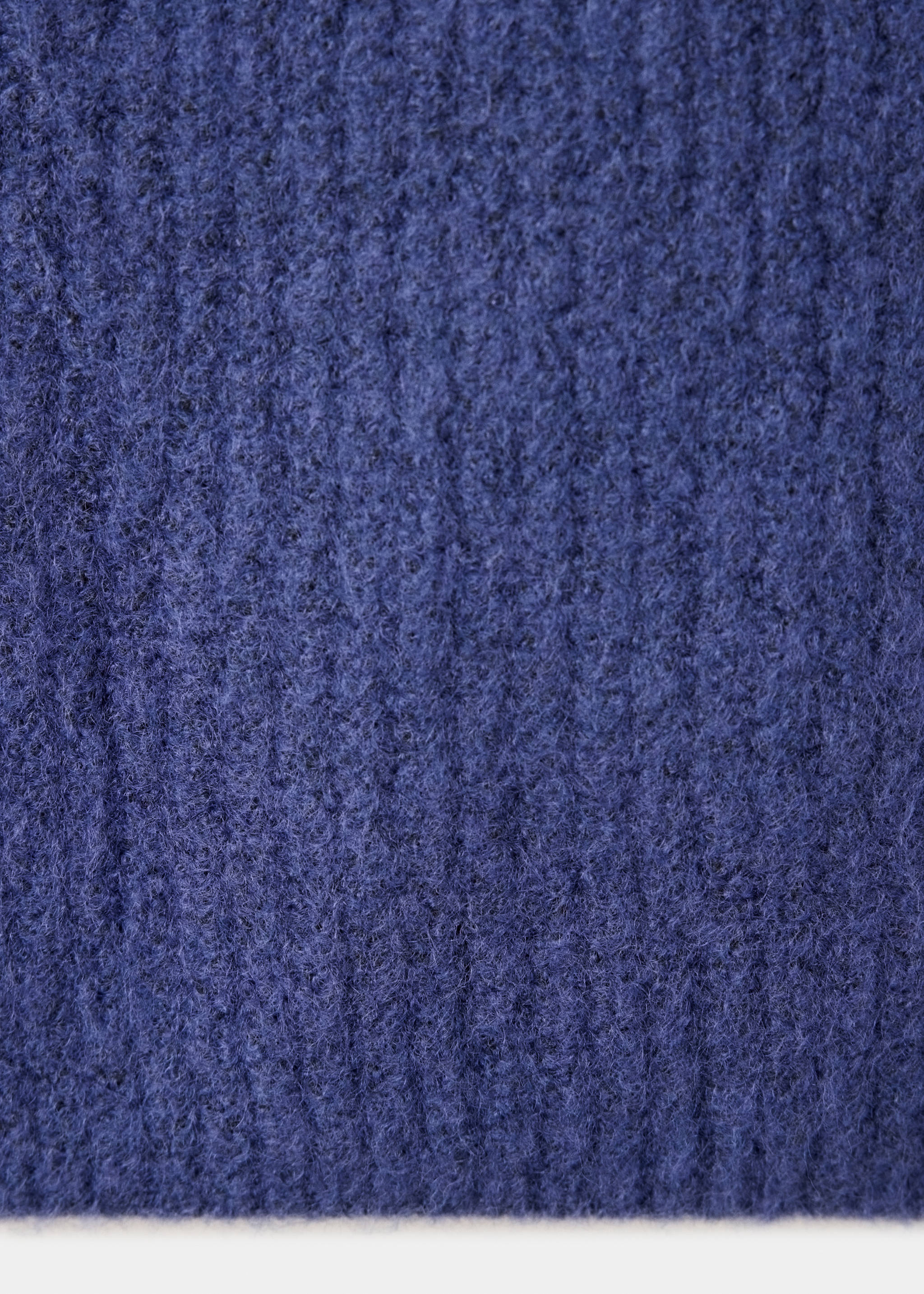Close-up of the dark blue textured knit fabric of a vest.
