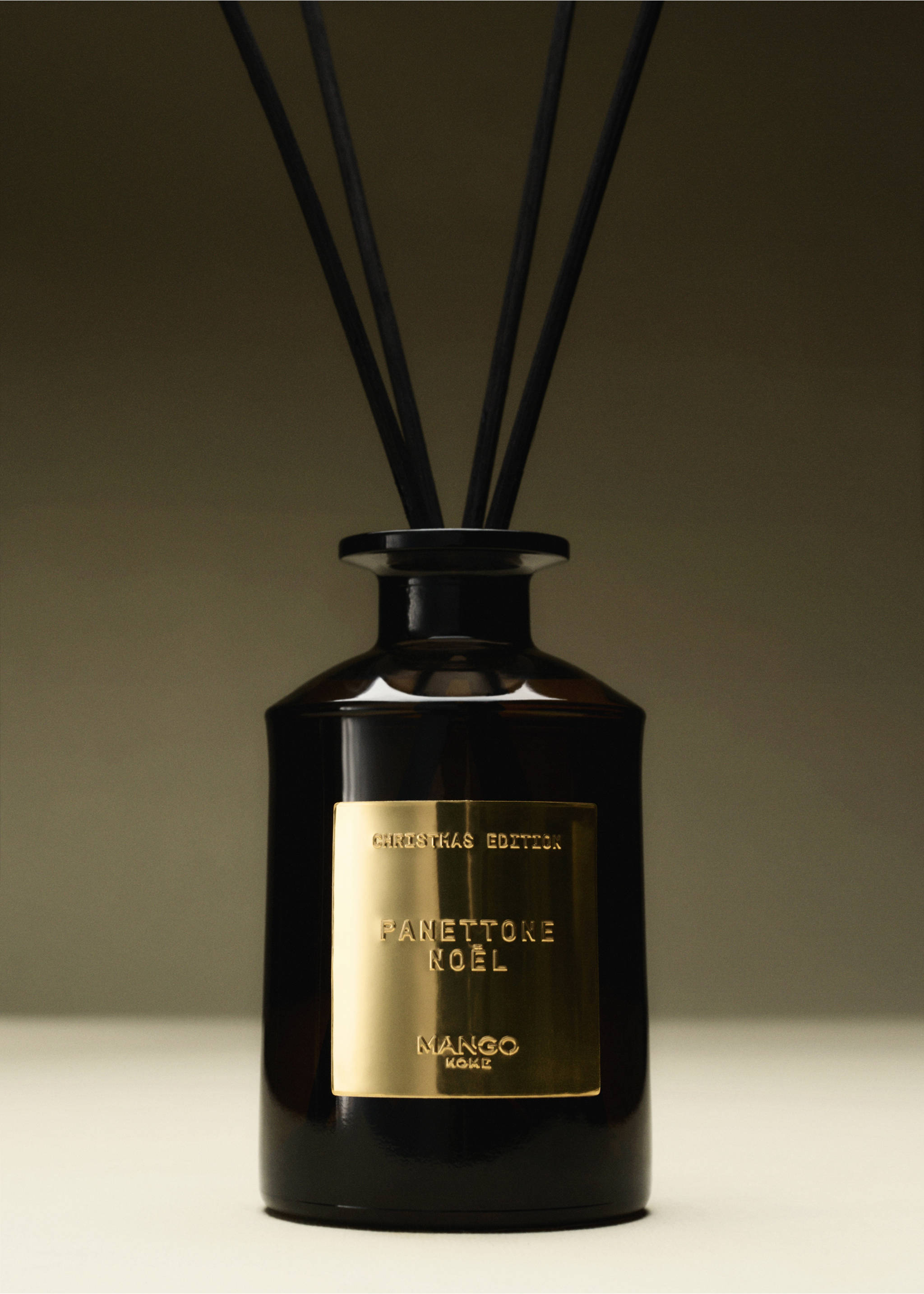 Dark brown glass reed diffuser bottle with a gold label and black sticks., Gold. Ref: 37077812-00.