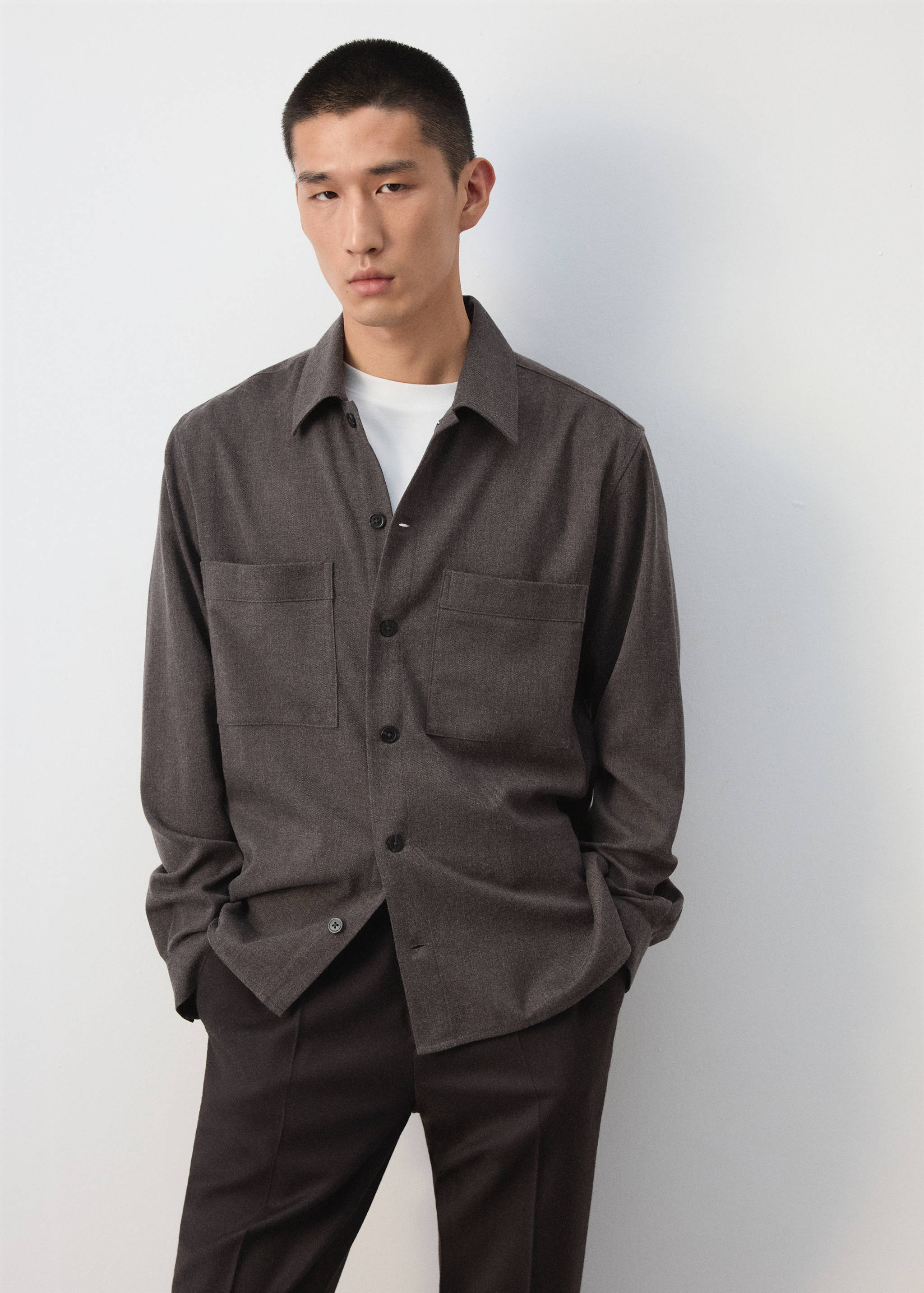 Dark brown overshirt with chest pockets worn over a white t-shirt.