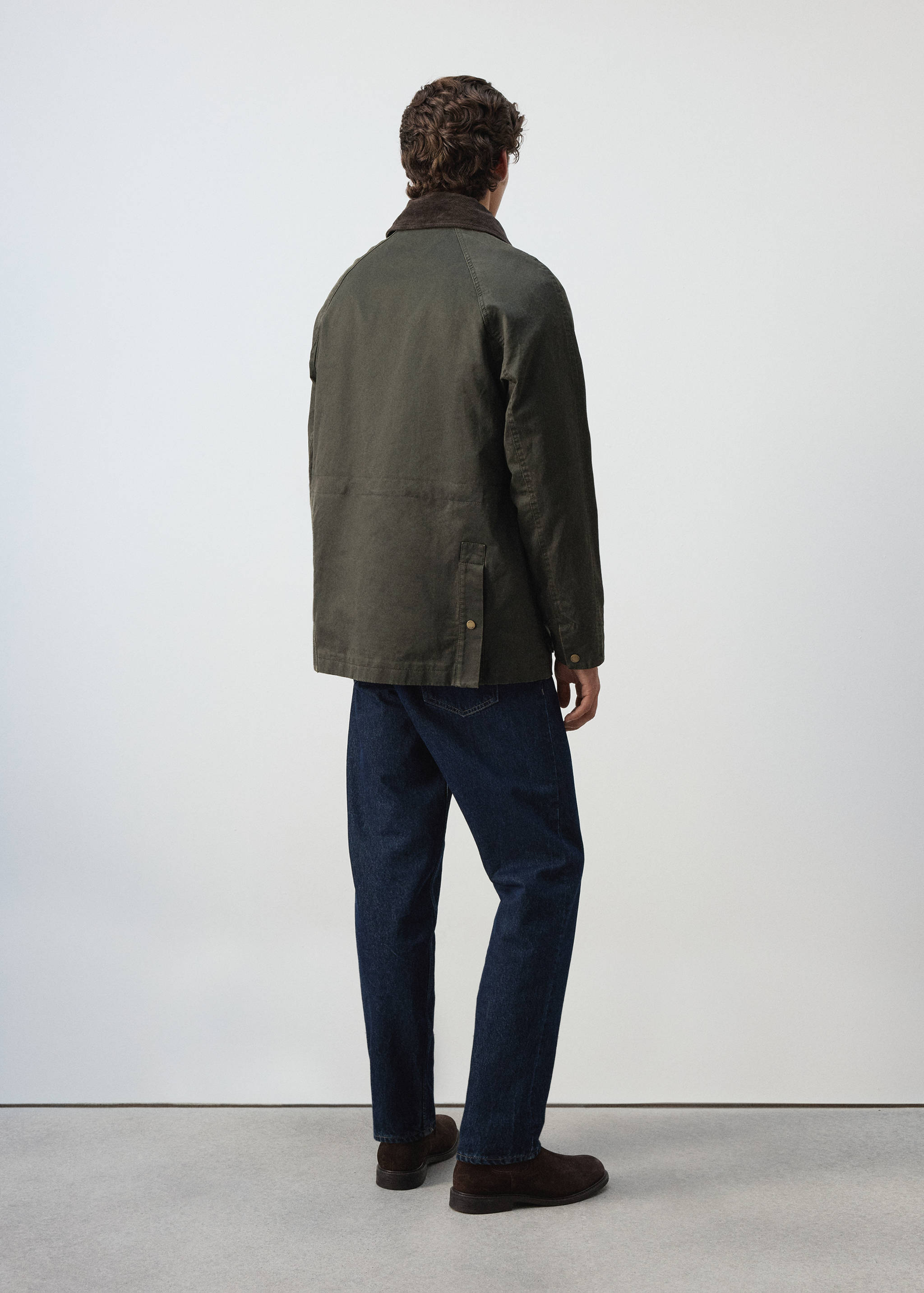 Dark green parka with a brown corduroy collar, back view.