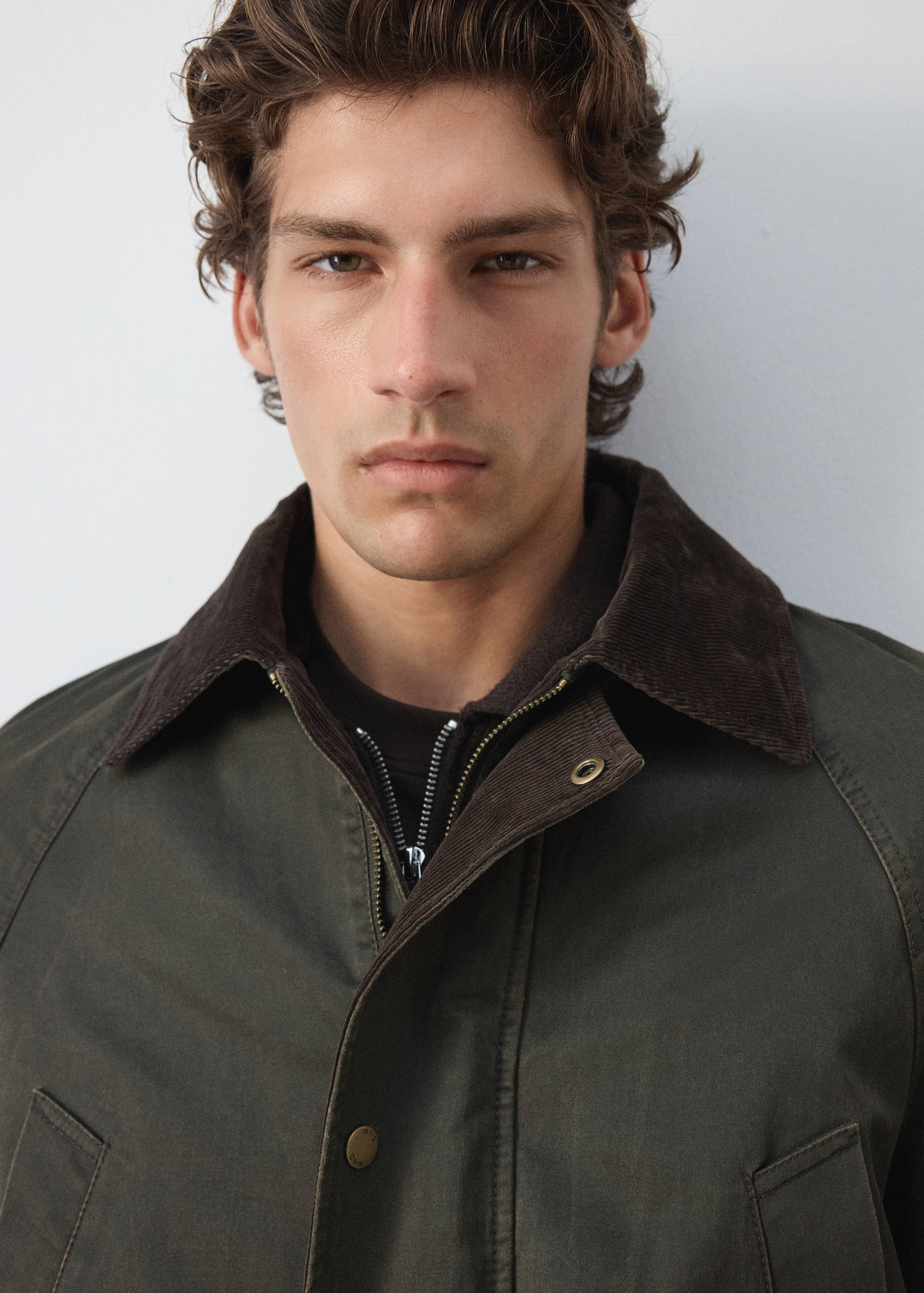 Dark green parka with a brown corduroy collar and zip fastening.