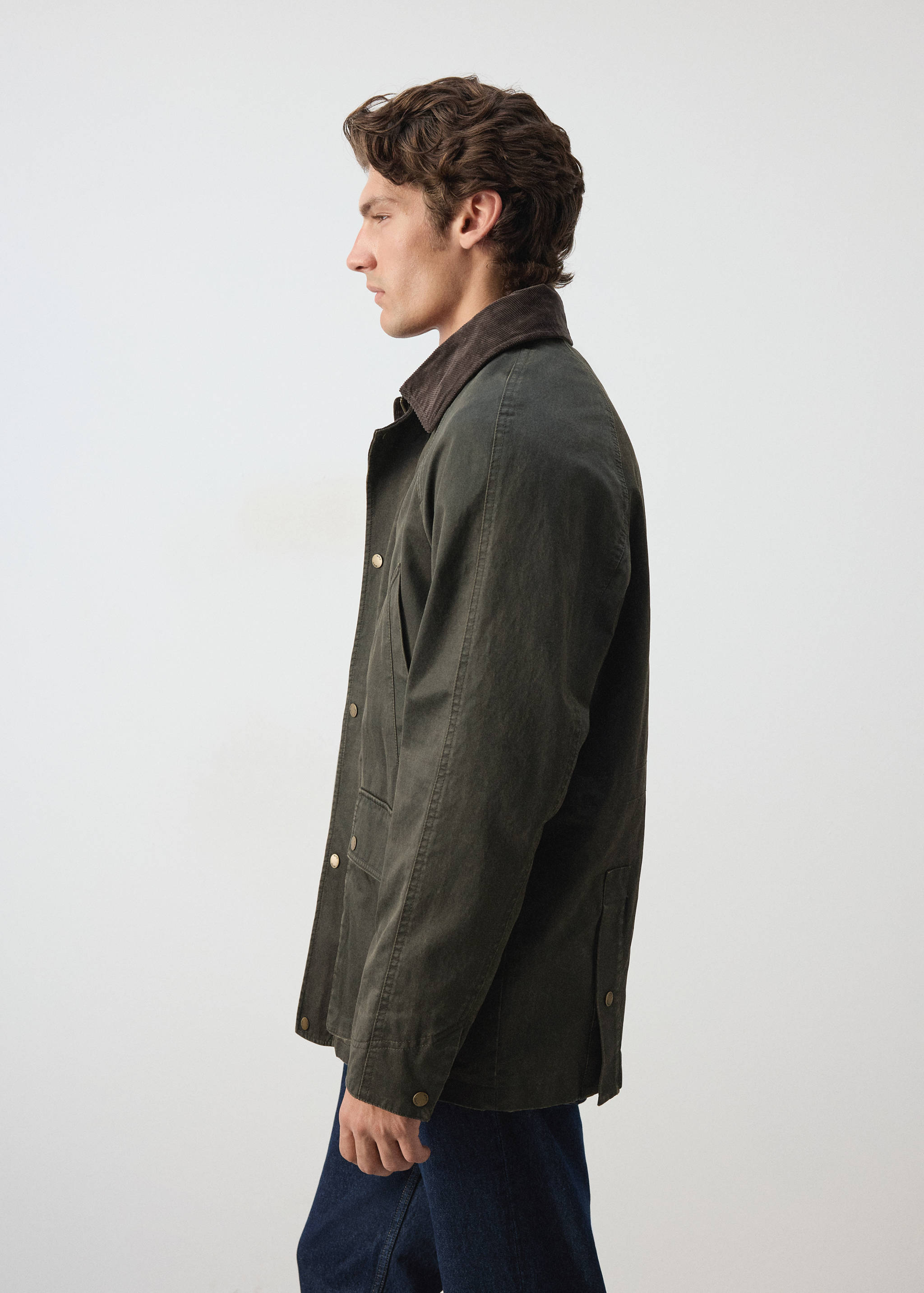 Dark green parka with a brown corduroy collar and snap button fastening.