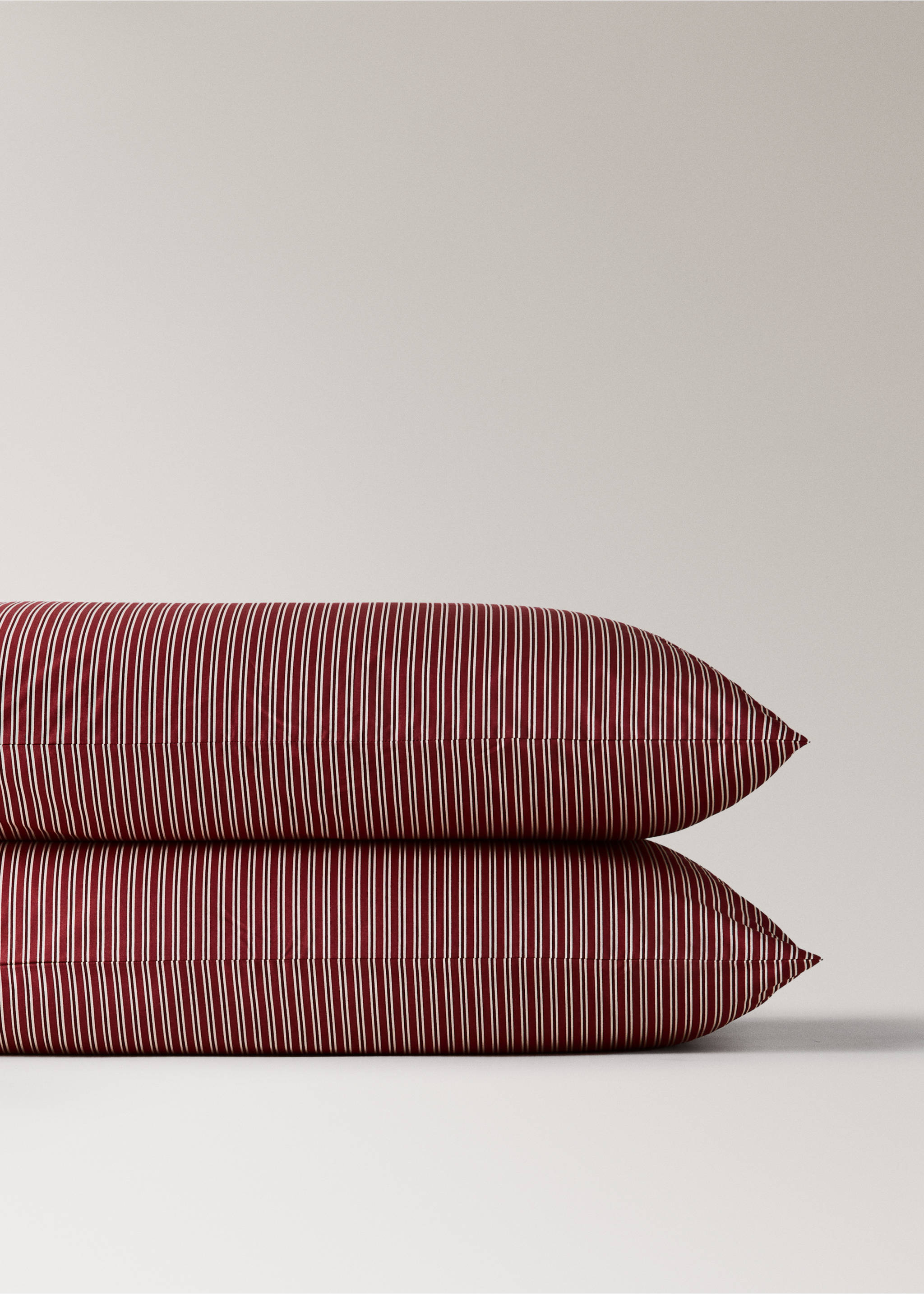 Close-up of two stacked red and white pinstriped pillowcases., Red. Ref: 37077888-00.