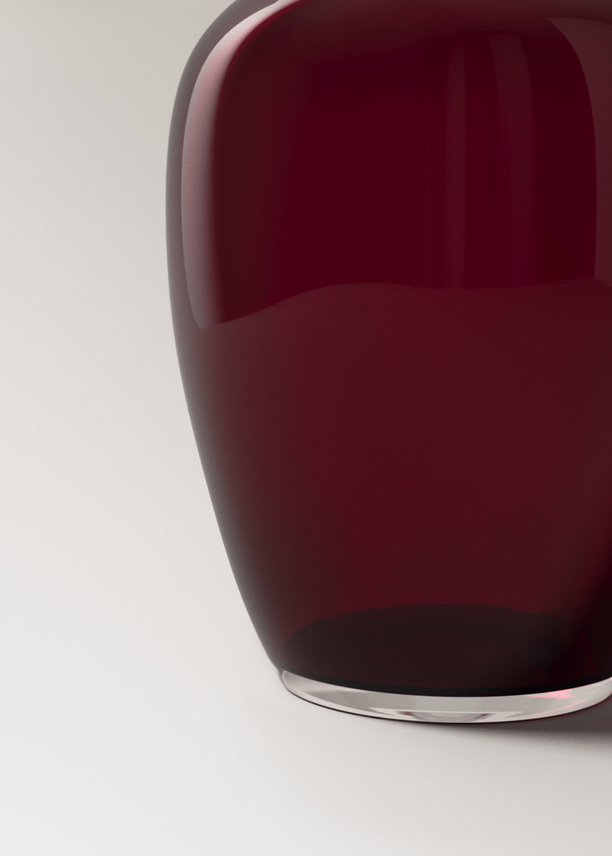 Close-up of a glossy deep red glass vase.
