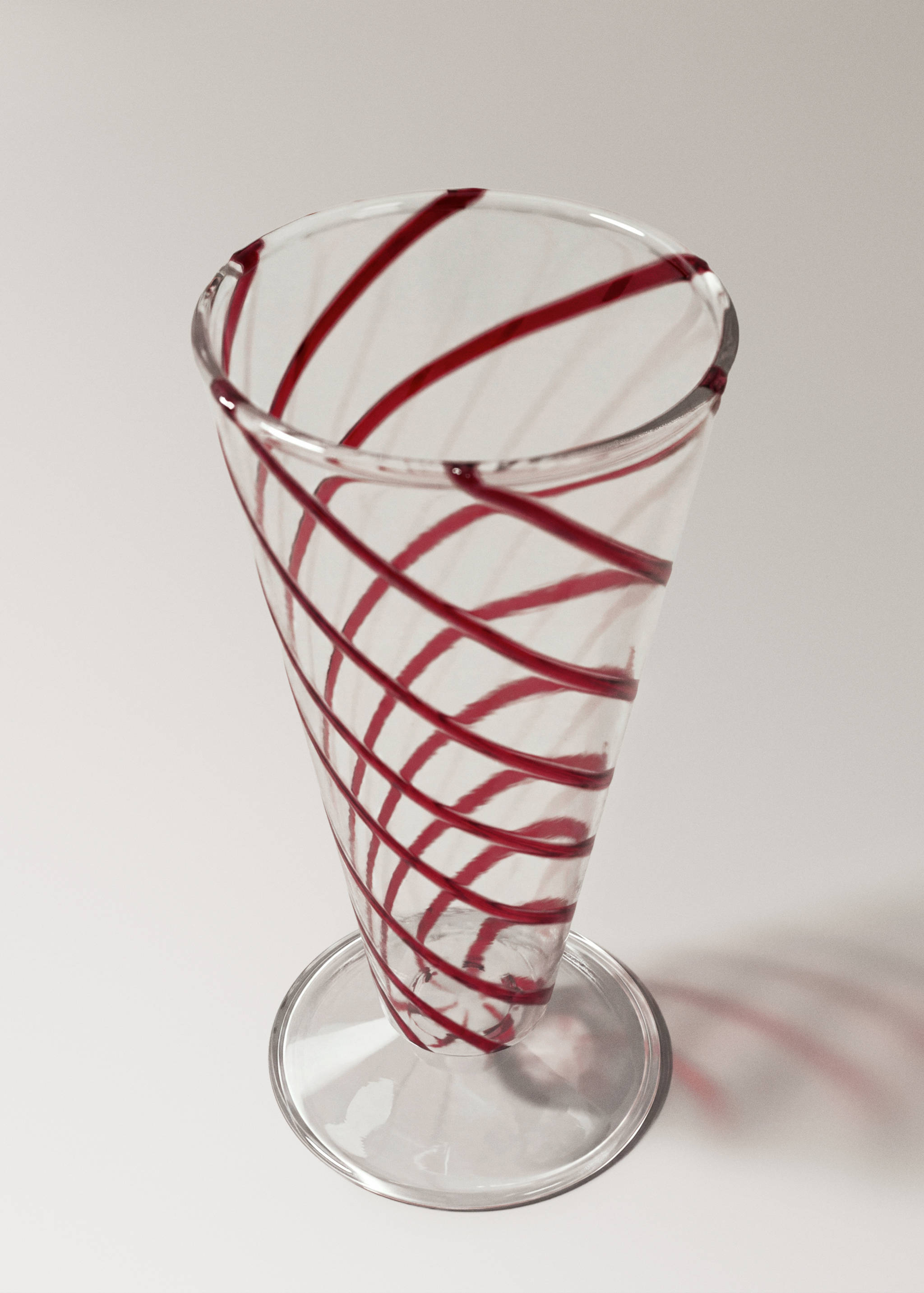 Clear glass goblet with red spiral stripes.