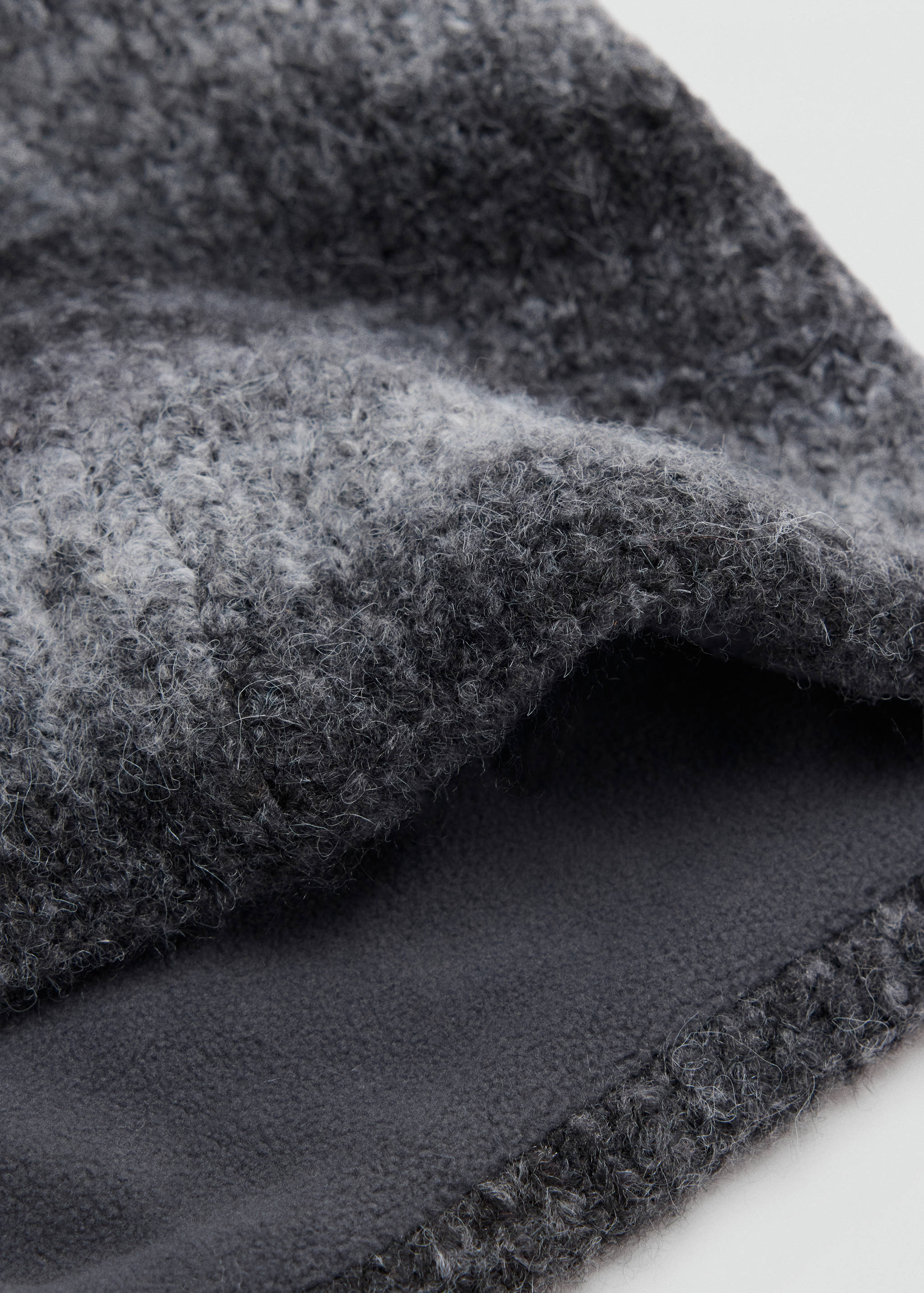 Dark grey knitted scarf with a fuzzy texture and smooth fleece lining.