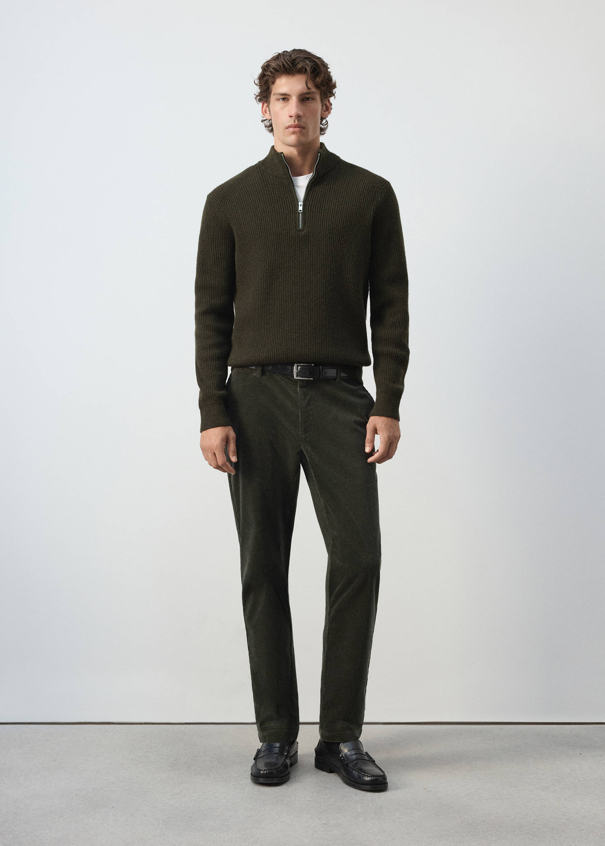 Dark green straight-fit trousers worn with a dark green zip-neck sweater