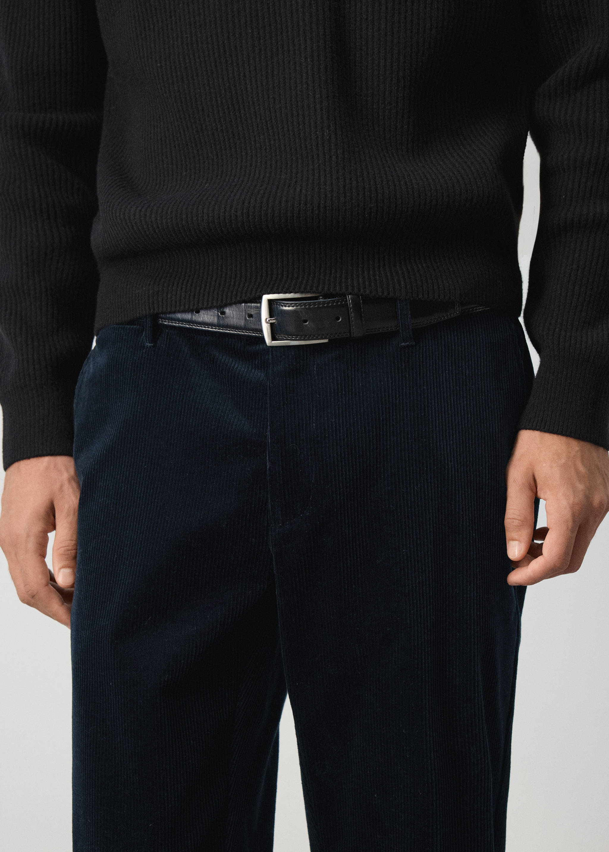Navy blue corduroy trousers paired with a black leather belt and jumper.