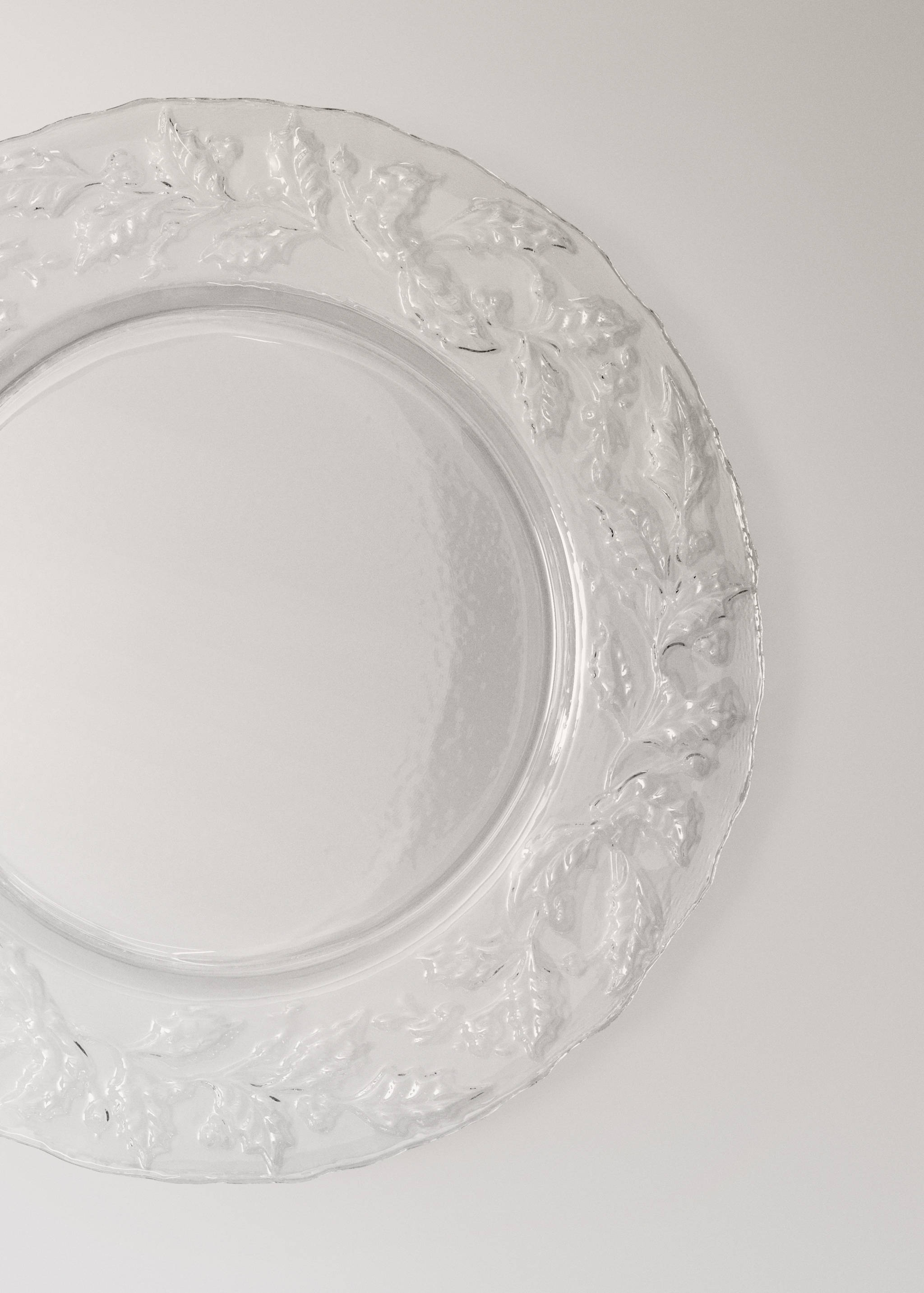 Clear glass plate with a textured relief leaf and berry rim detail.