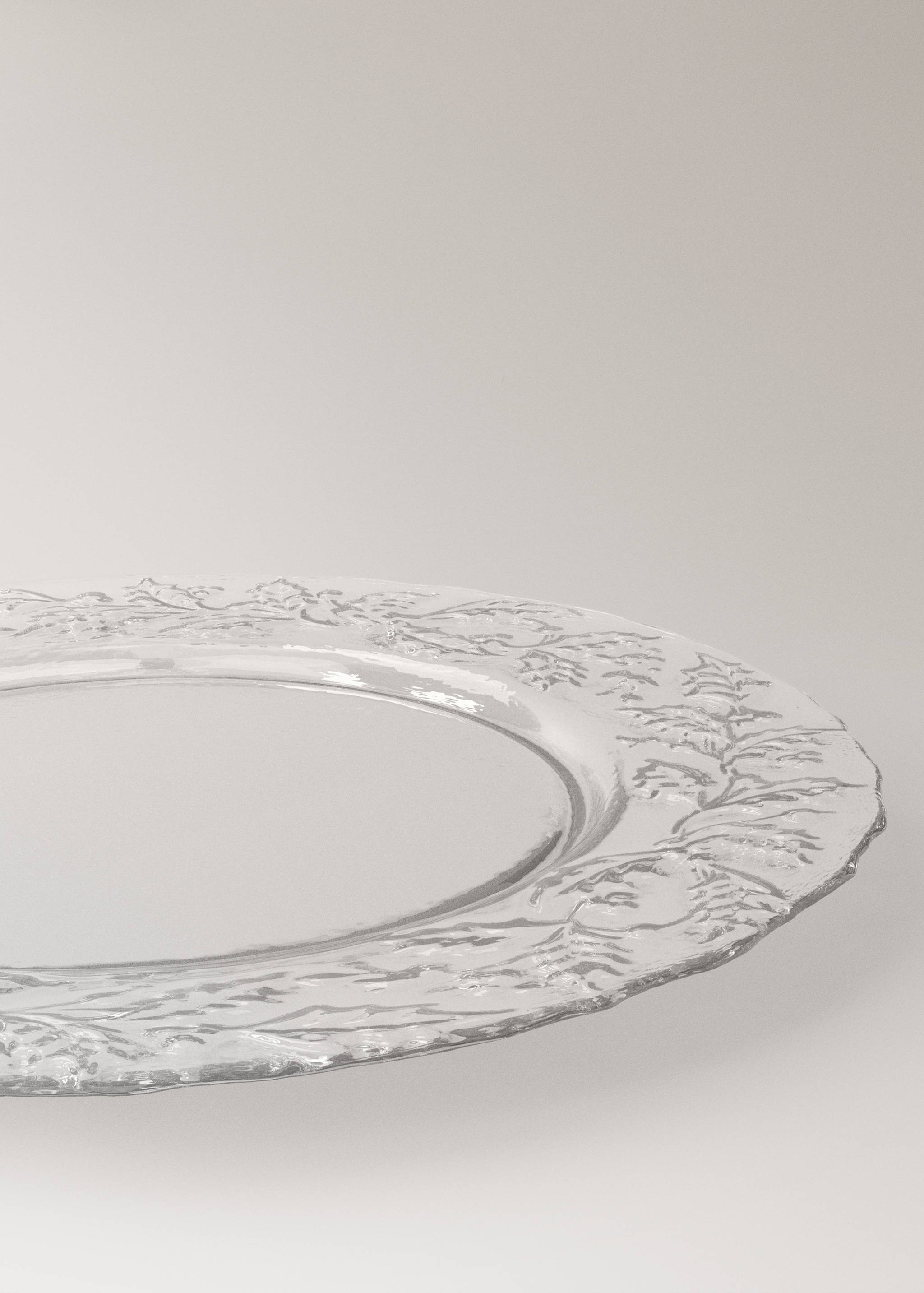 Clear glass plate with an embossed botanical rim.