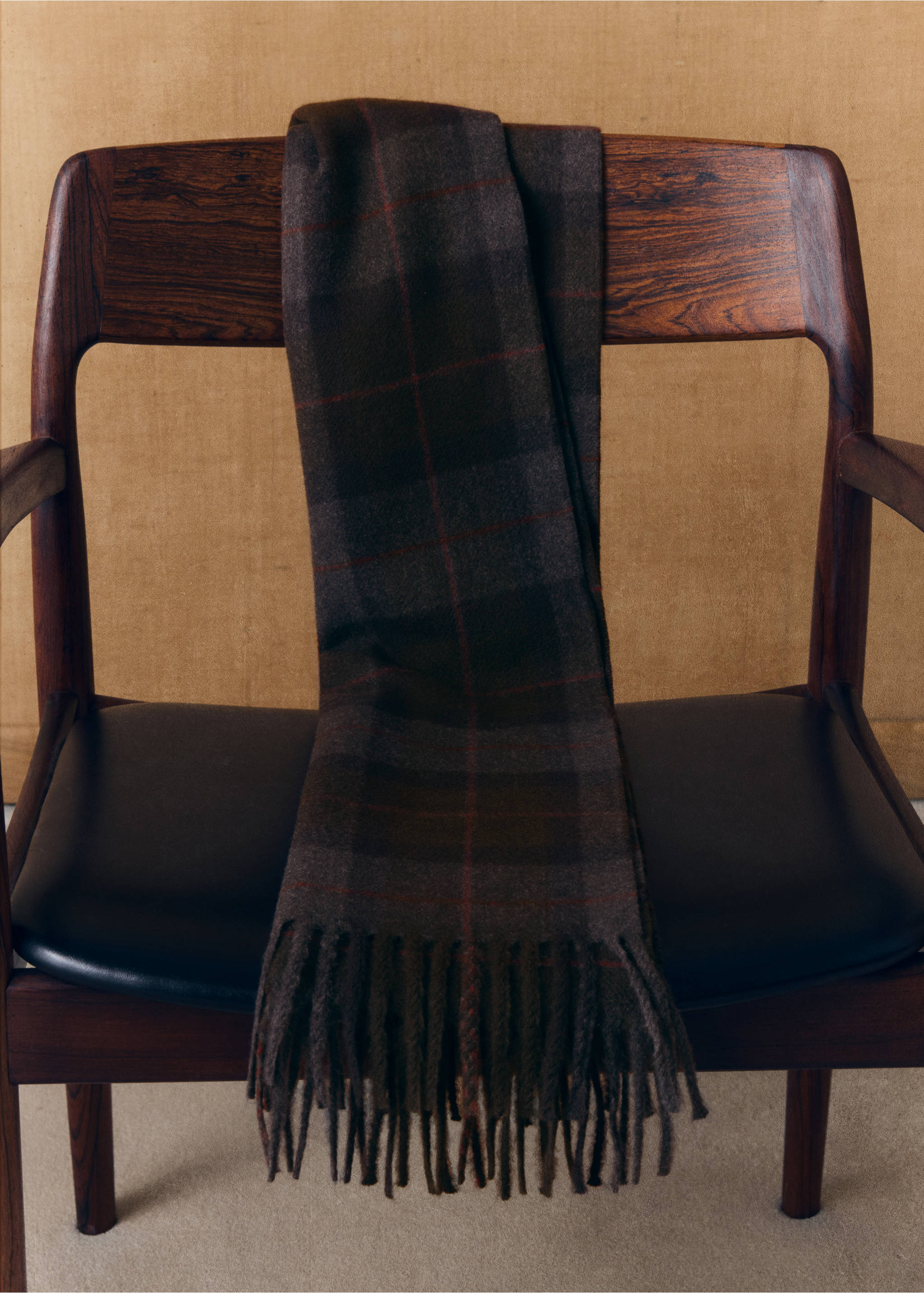 Dark brown plaid scarf with fringed ends draped on a wooden chair., Khaki. Ref: 37077902-00.
