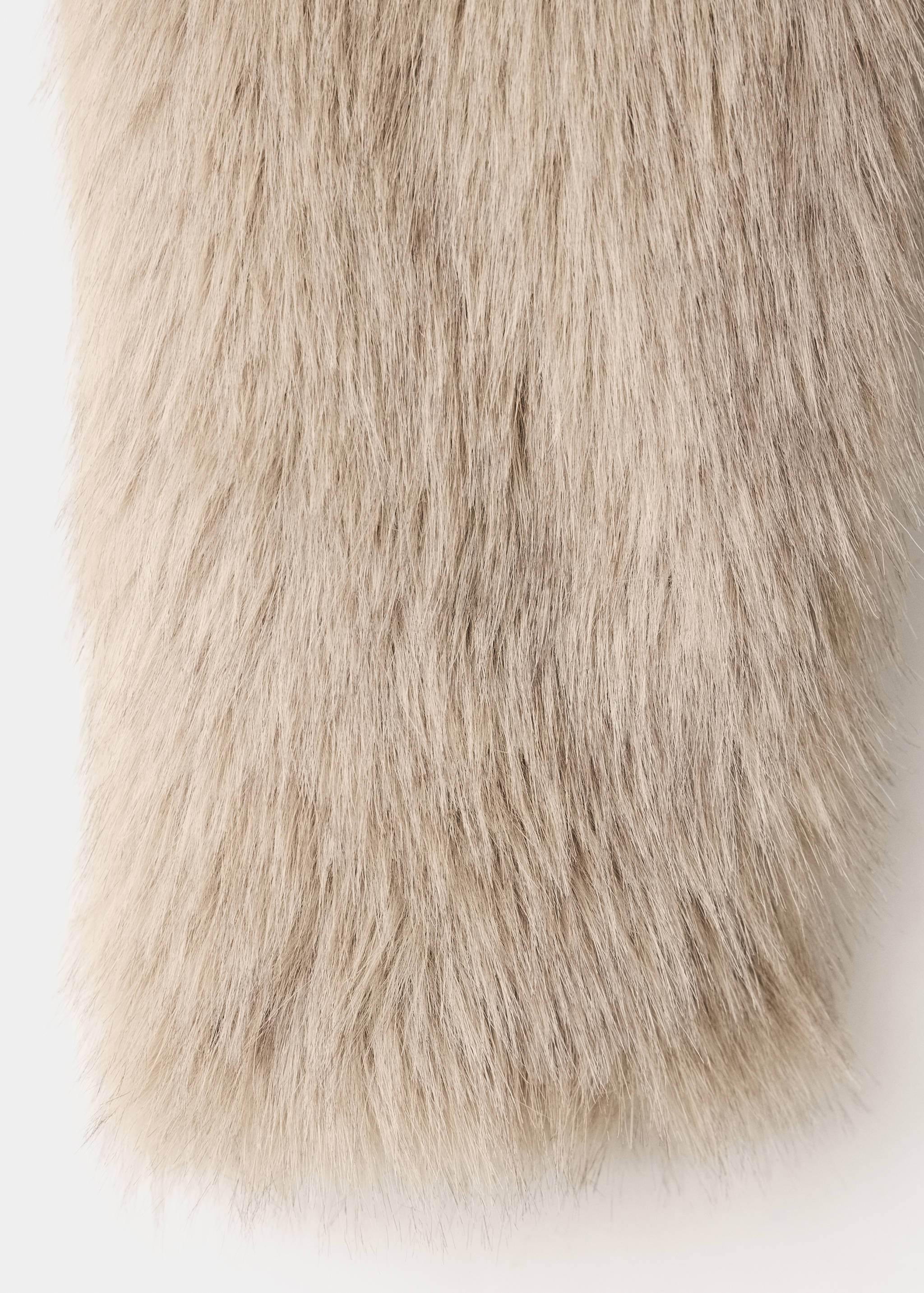 Close-up of beige faux-fur coat fabric texture.