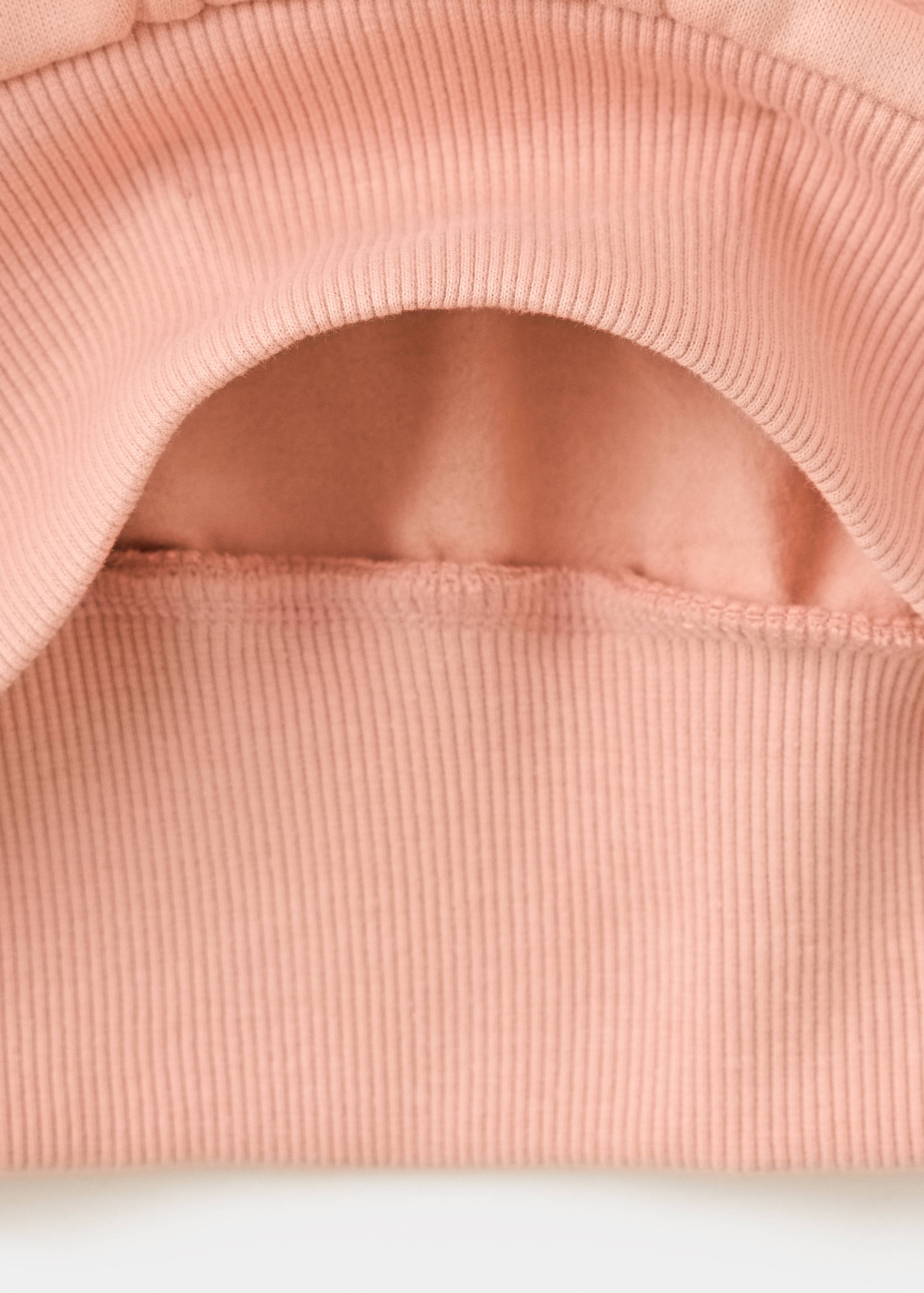 Detalle de sudadera infantil en color rosa que muestra el bajo de canalé.