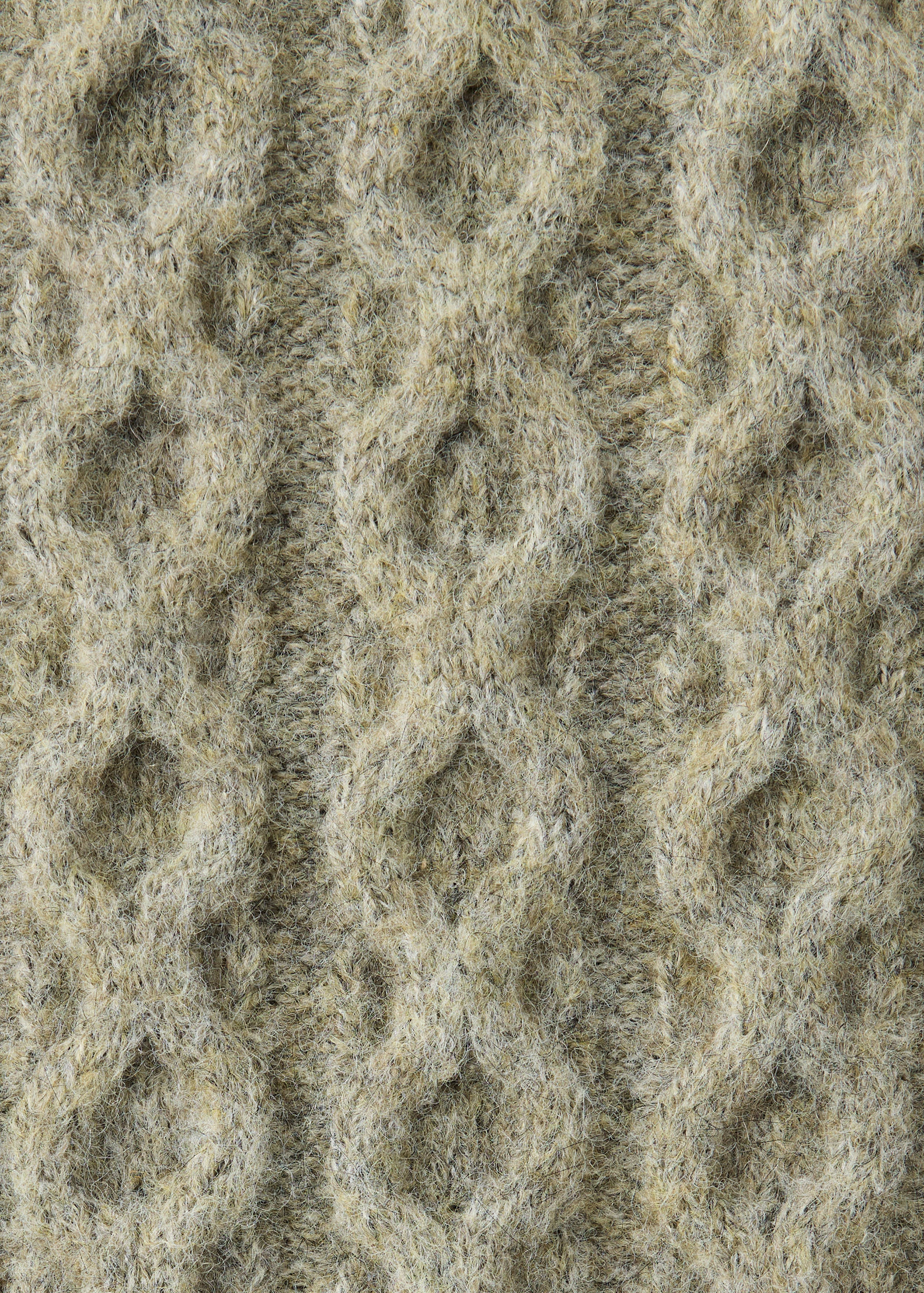 Detalle de la textura del tejido de punto trenzado beige de un jersey.