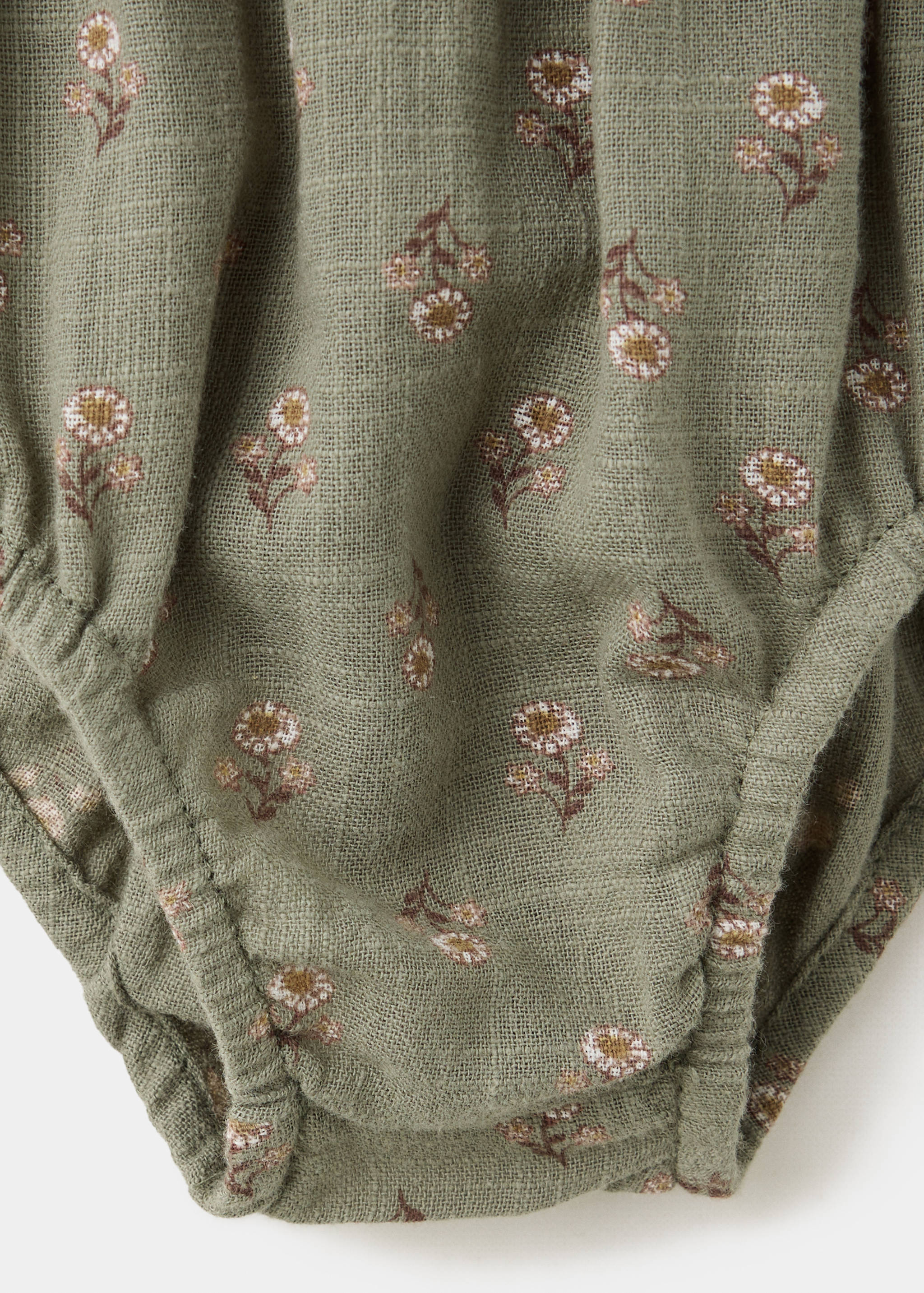 Close-up of the sage green floral fabric on a children's dress.