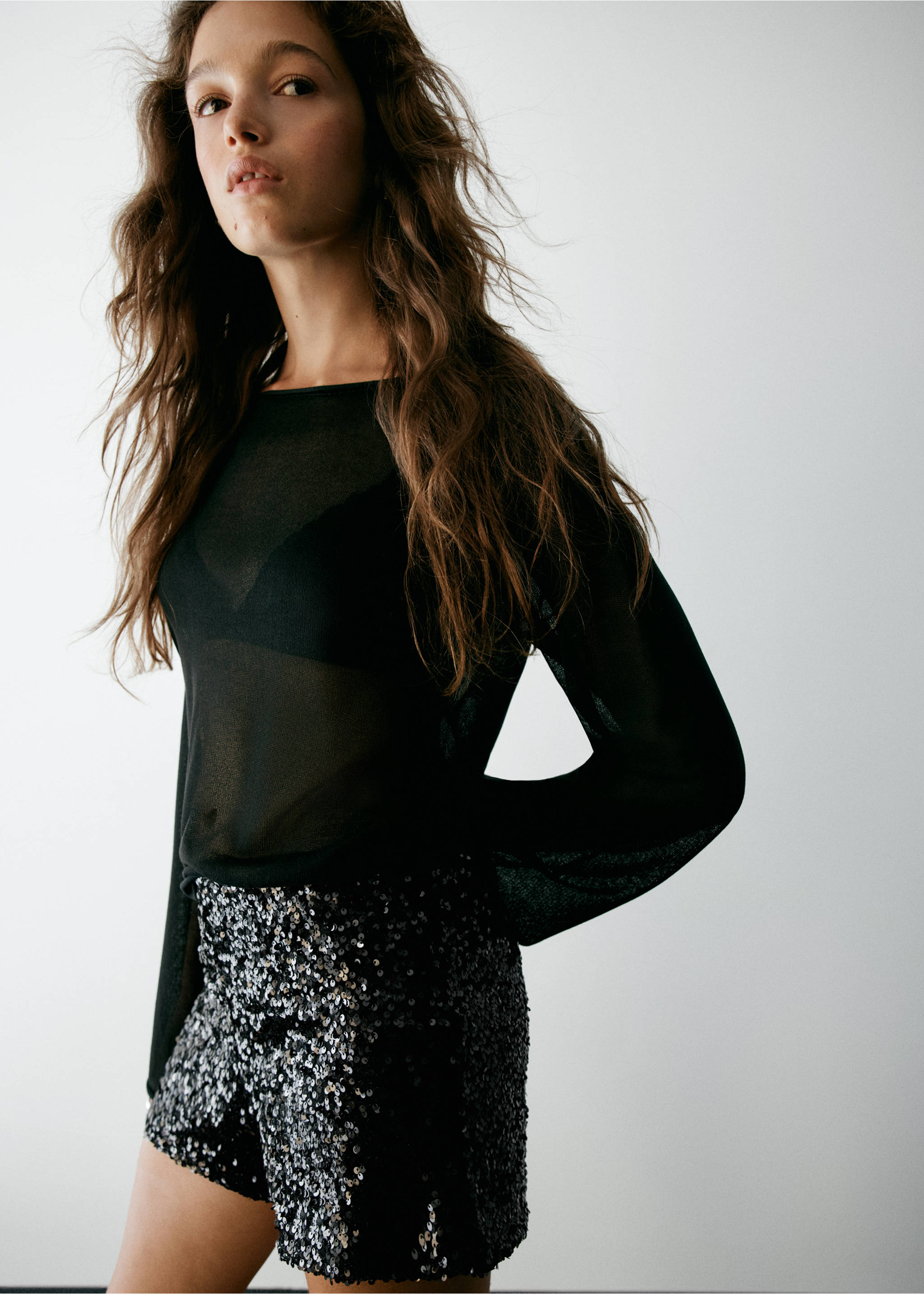 Black sequin shorts worn with a sheer black top., Black. Ref: 37077929-00.
