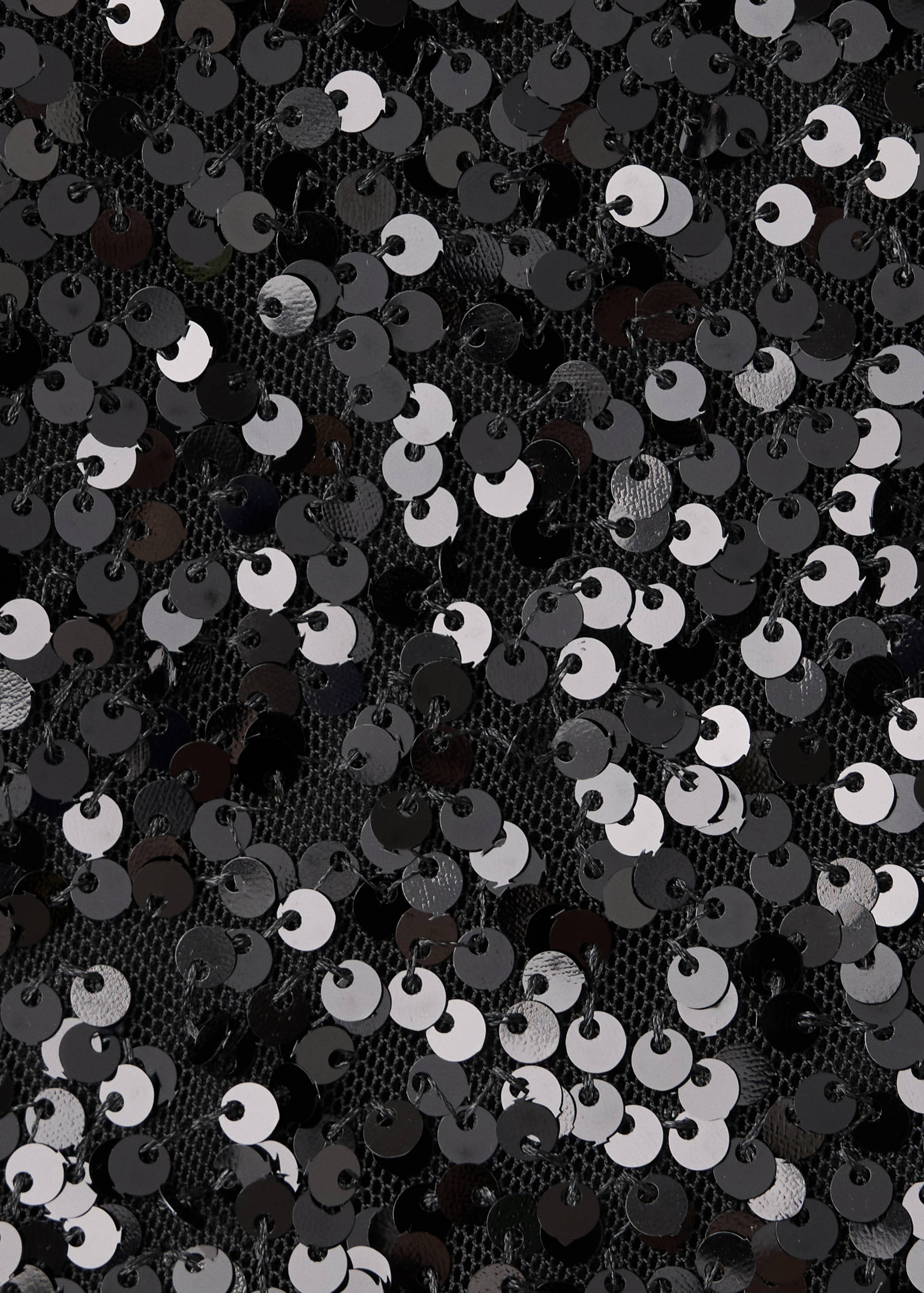 Close-up of black sequin fabric texture on the shorts.