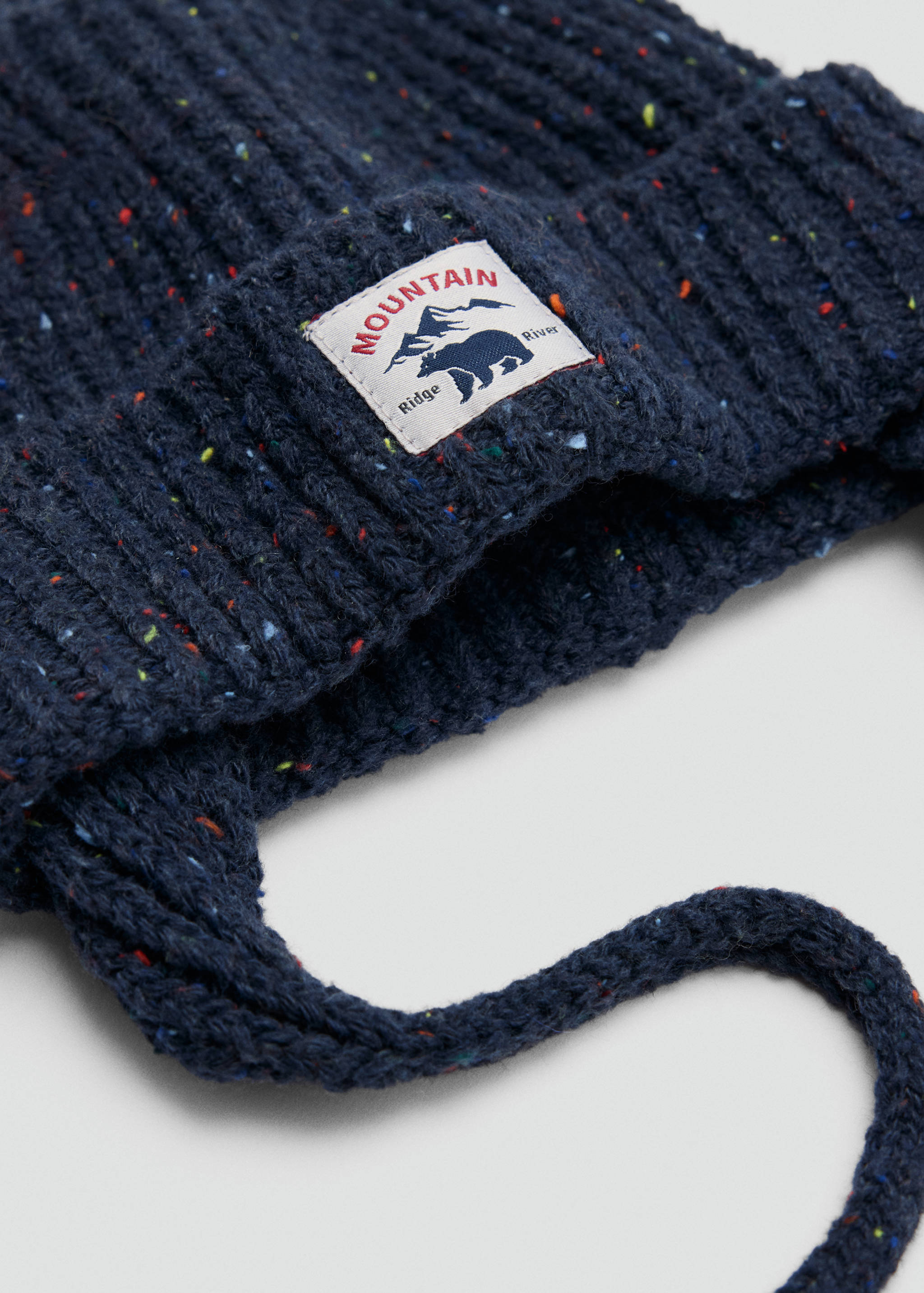 Navy blue ribbed knit beanie with multicoloured flecks and a branded patch.