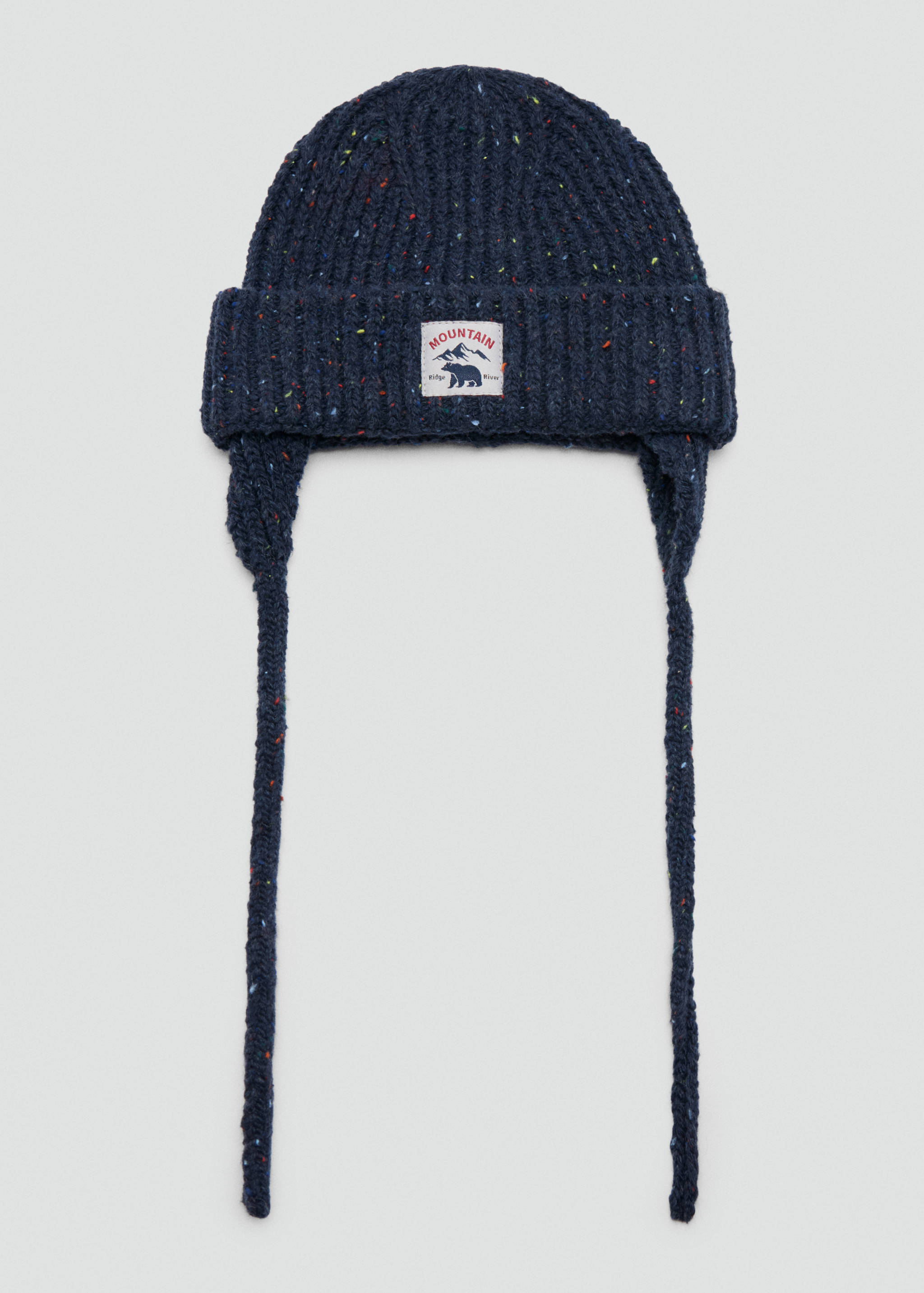 Navy blue speckled knit kids' beanie with earflaps, braided ties, and a mountain graphic patch.