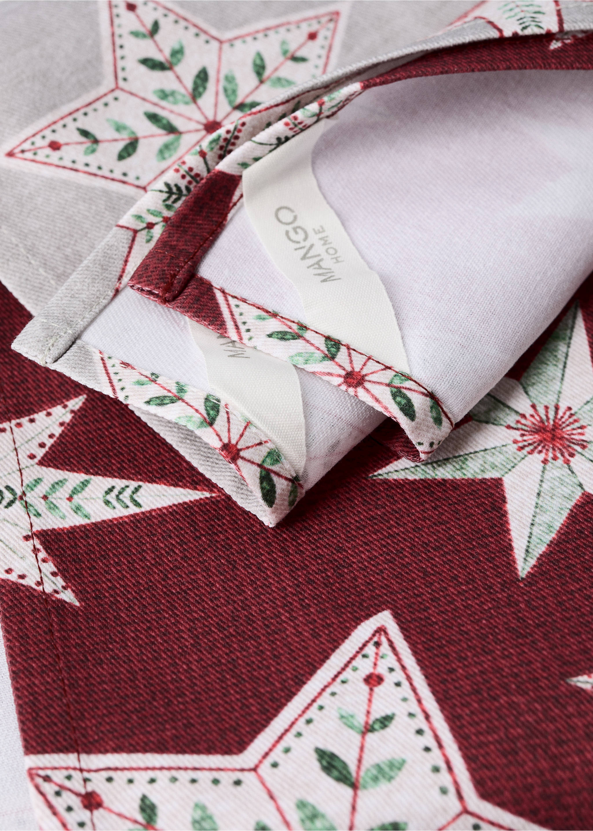 Close-up of a Christmas star print kitchen towel with a Mango Home label., Red. Ref: 37078268-00.