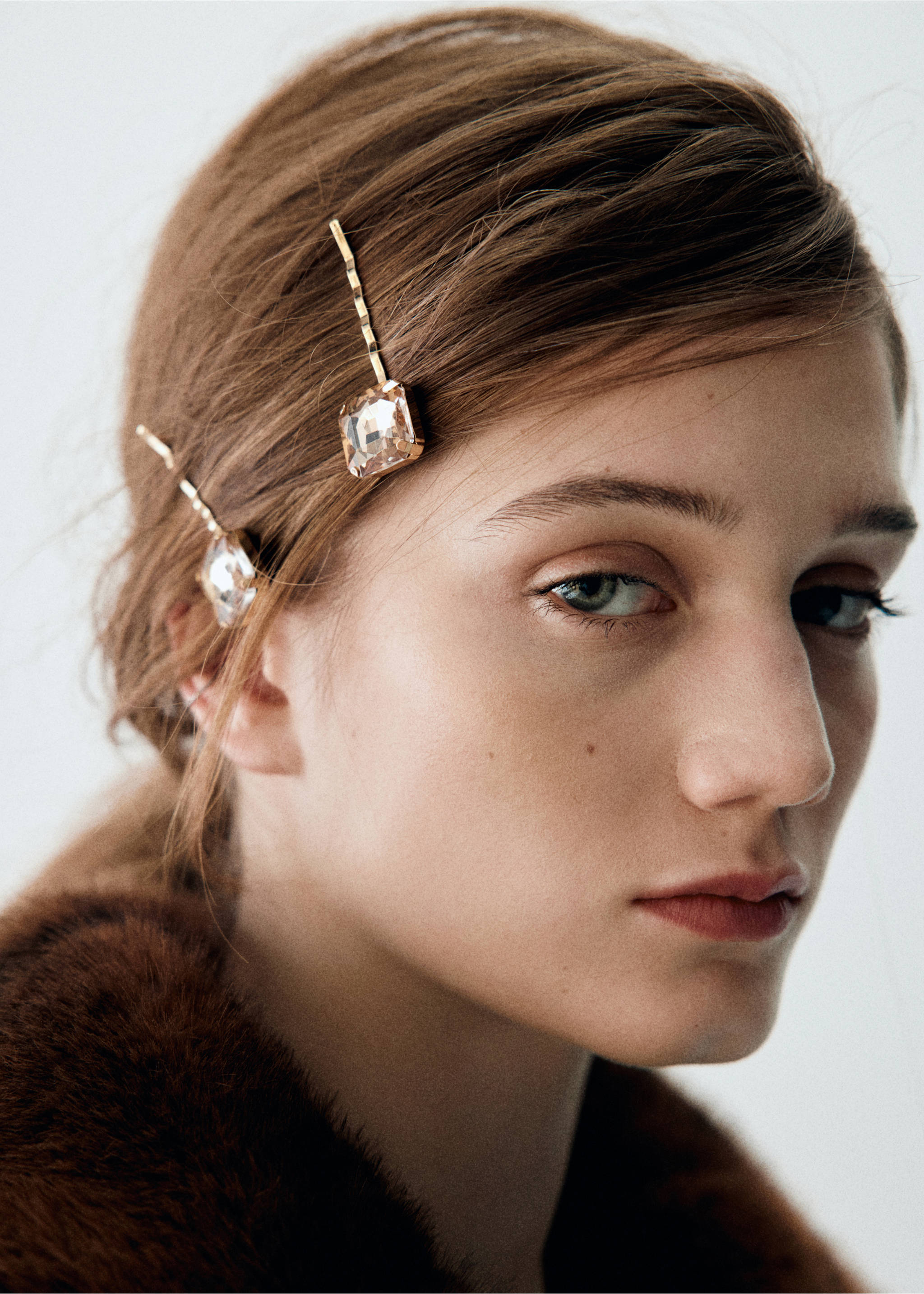 Two gold-toned bobby pins with square crystal stones worn in the hair., Gold. Ref: 37078269-00.