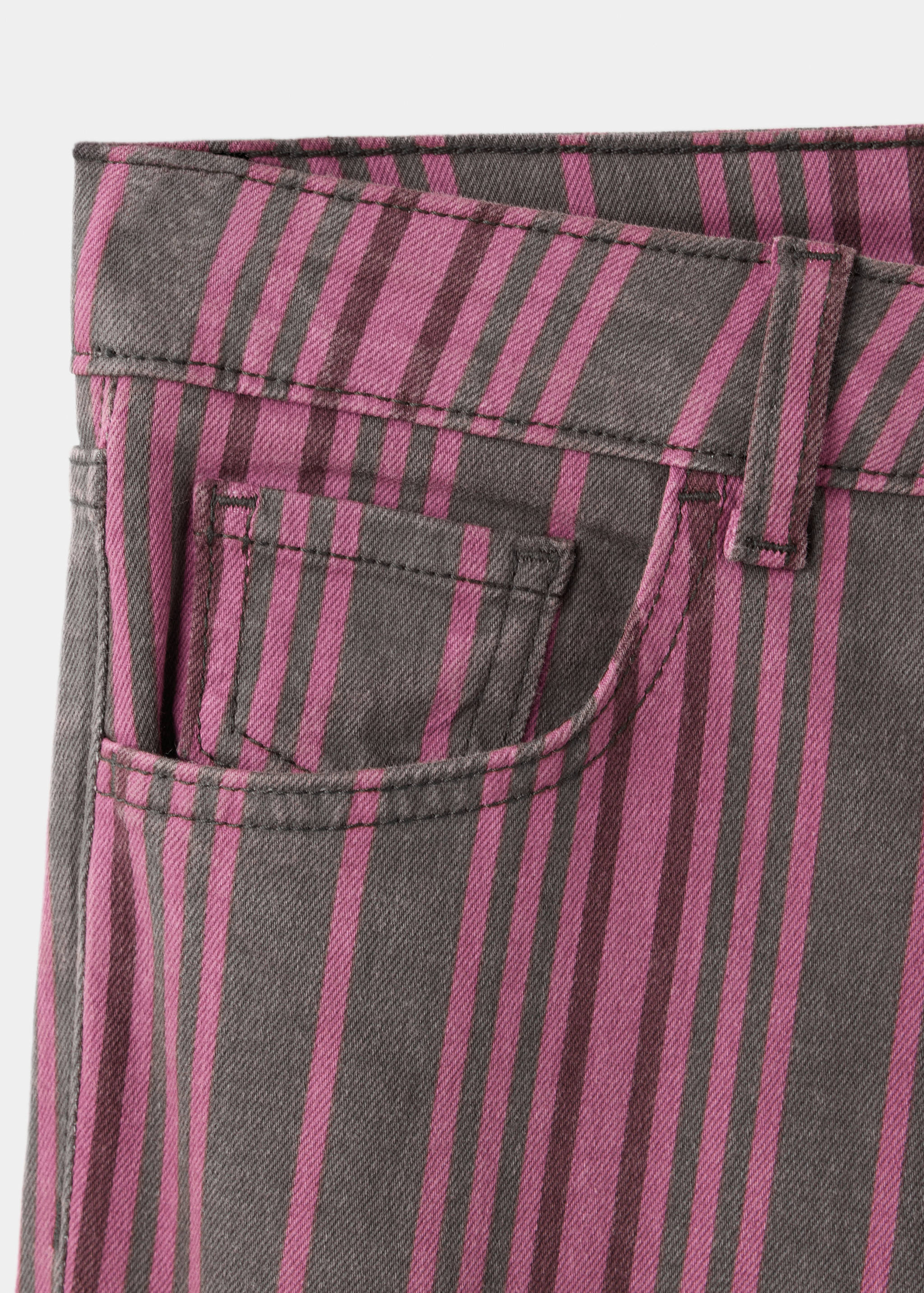 Primer plano de unos pantalones vaqueros de rayas gris oscuro y magenta que muestran la pretina.