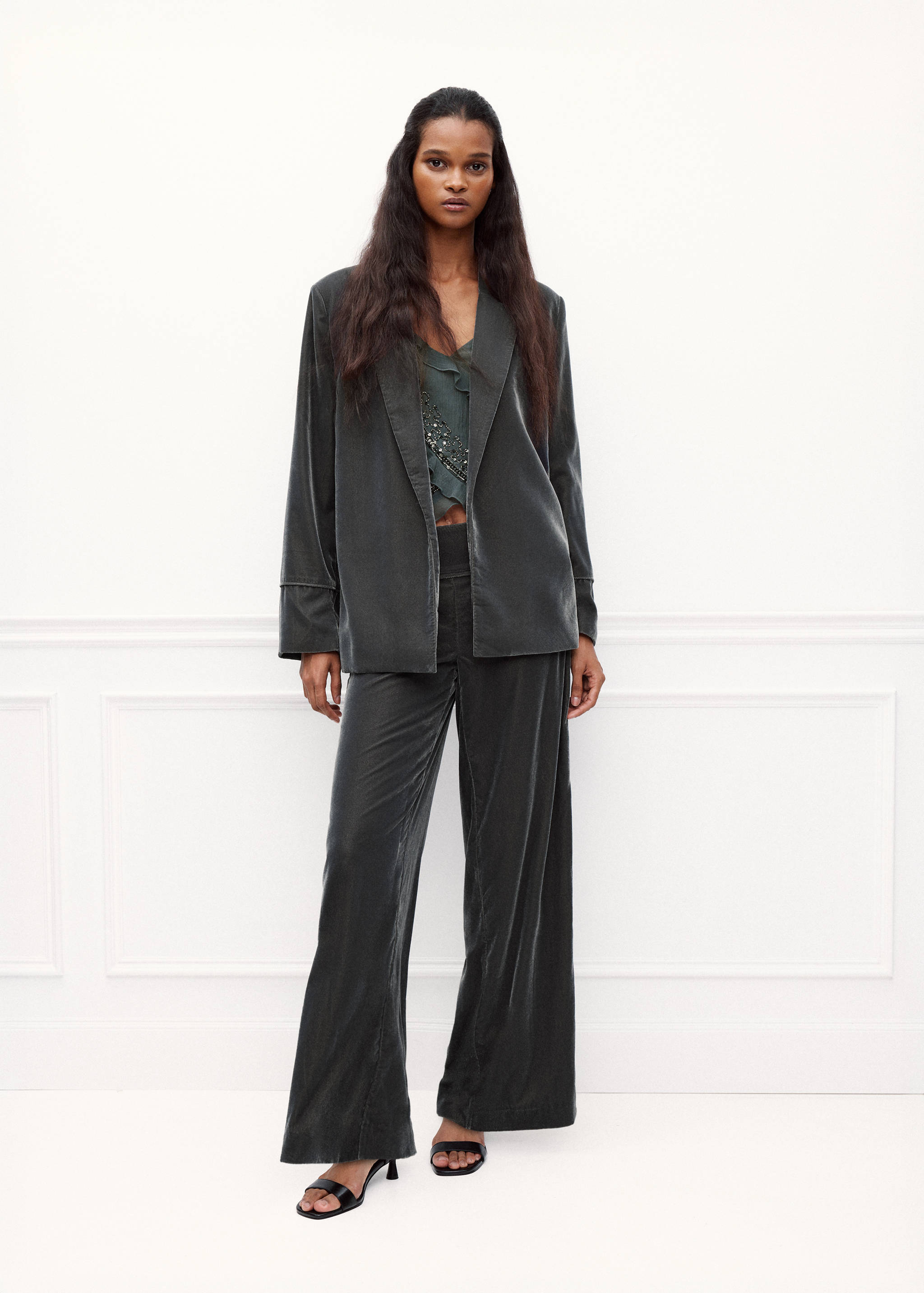 Chaqueta de terciopelo gris oscuro combinada con pantalones wide-leg a juego y un top.