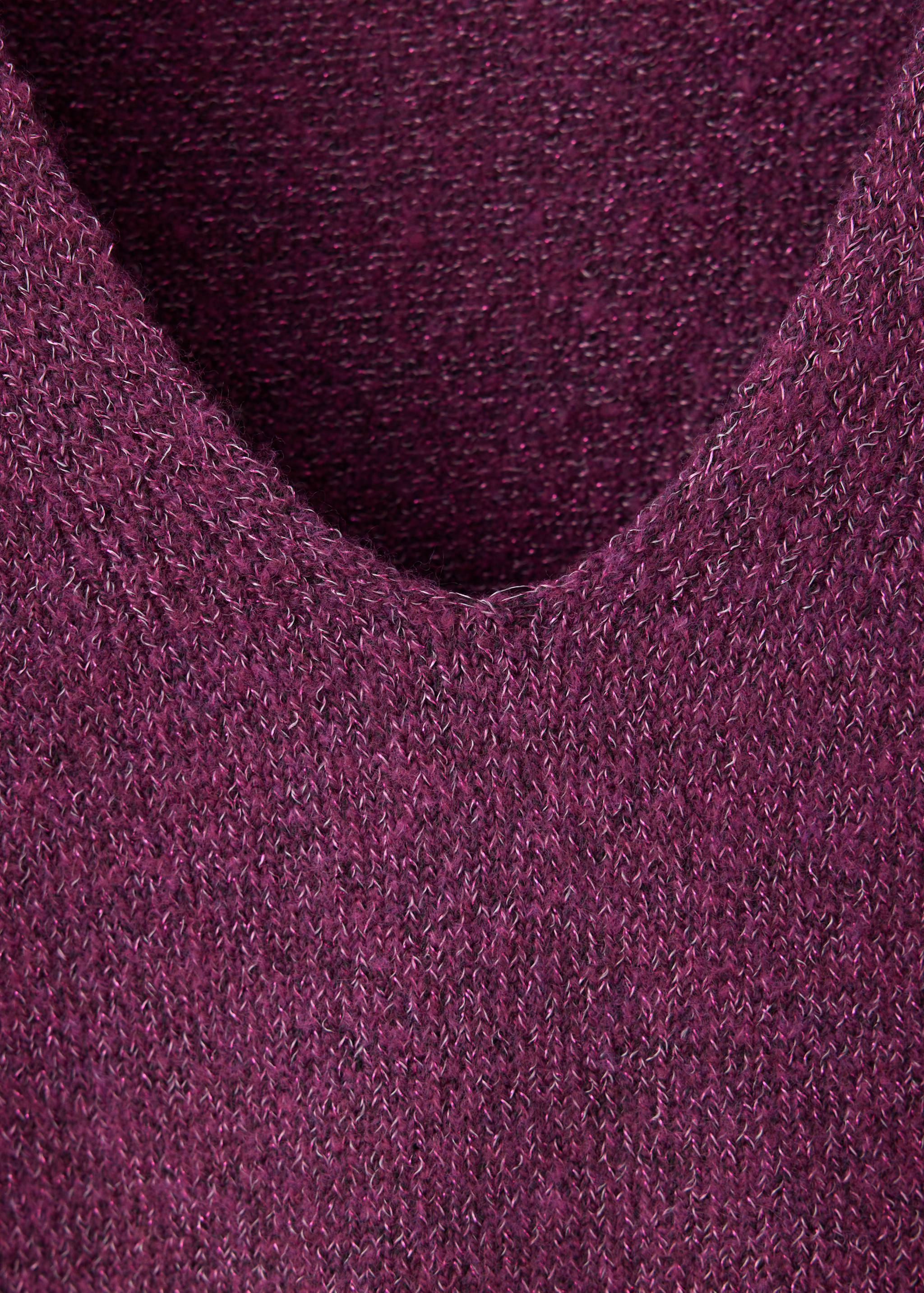 Close-up of a dark plum purple knitted jersey sweater showing the V-neckline.