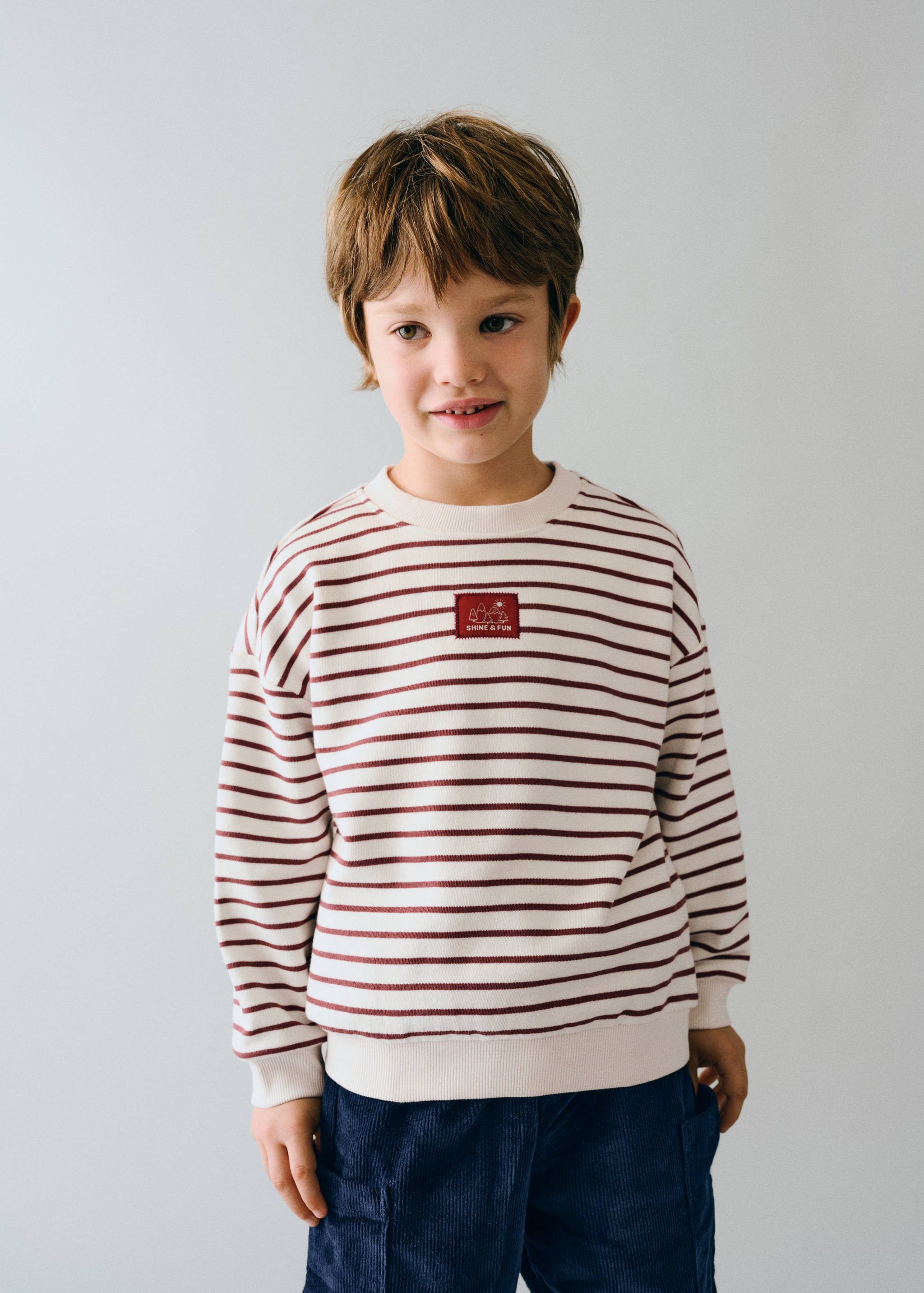 Kids' cream and maroon striped crewneck sweatshirt with chest patch.