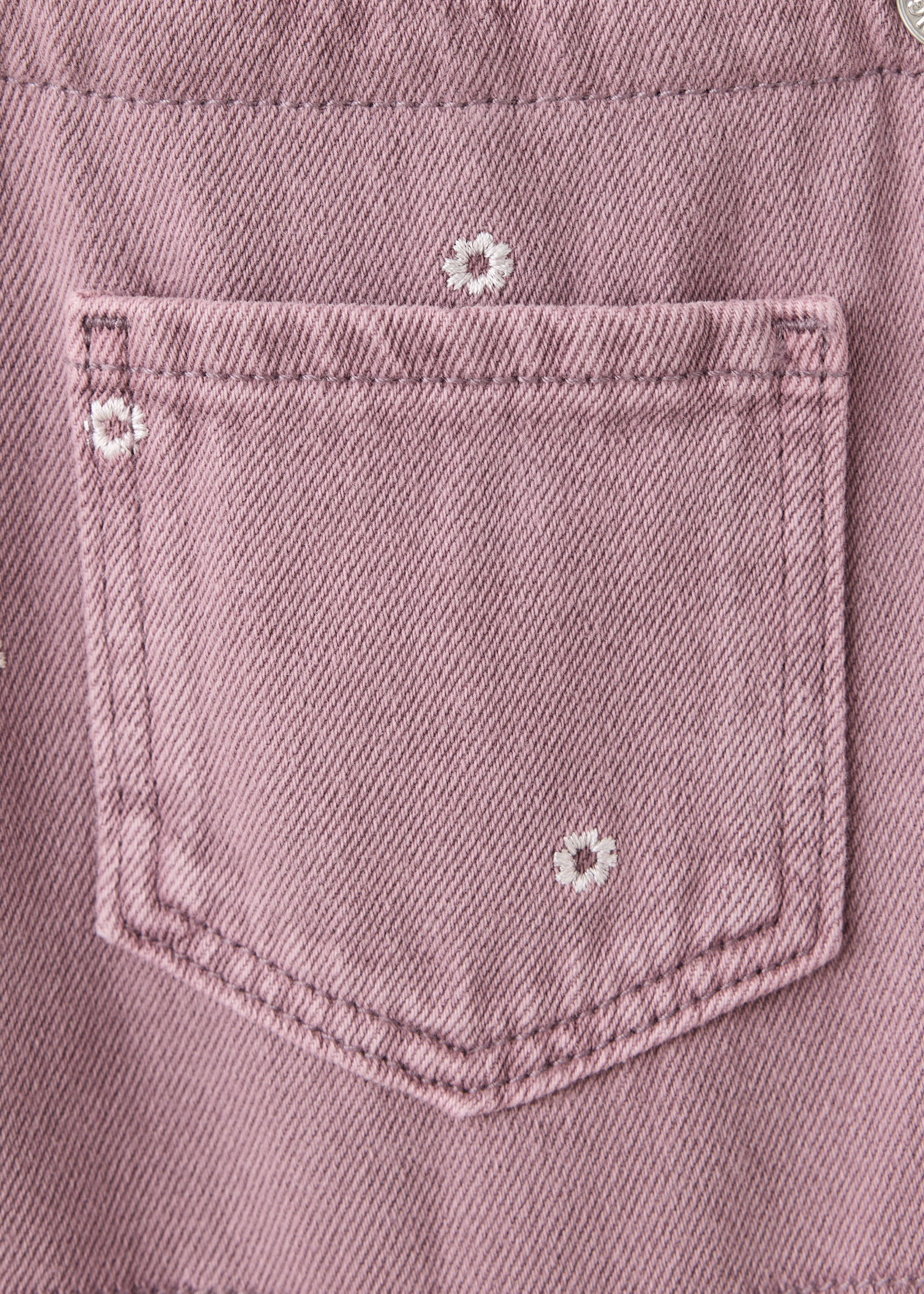 Mauve pink denim dungaree detail with embroidered flowers.