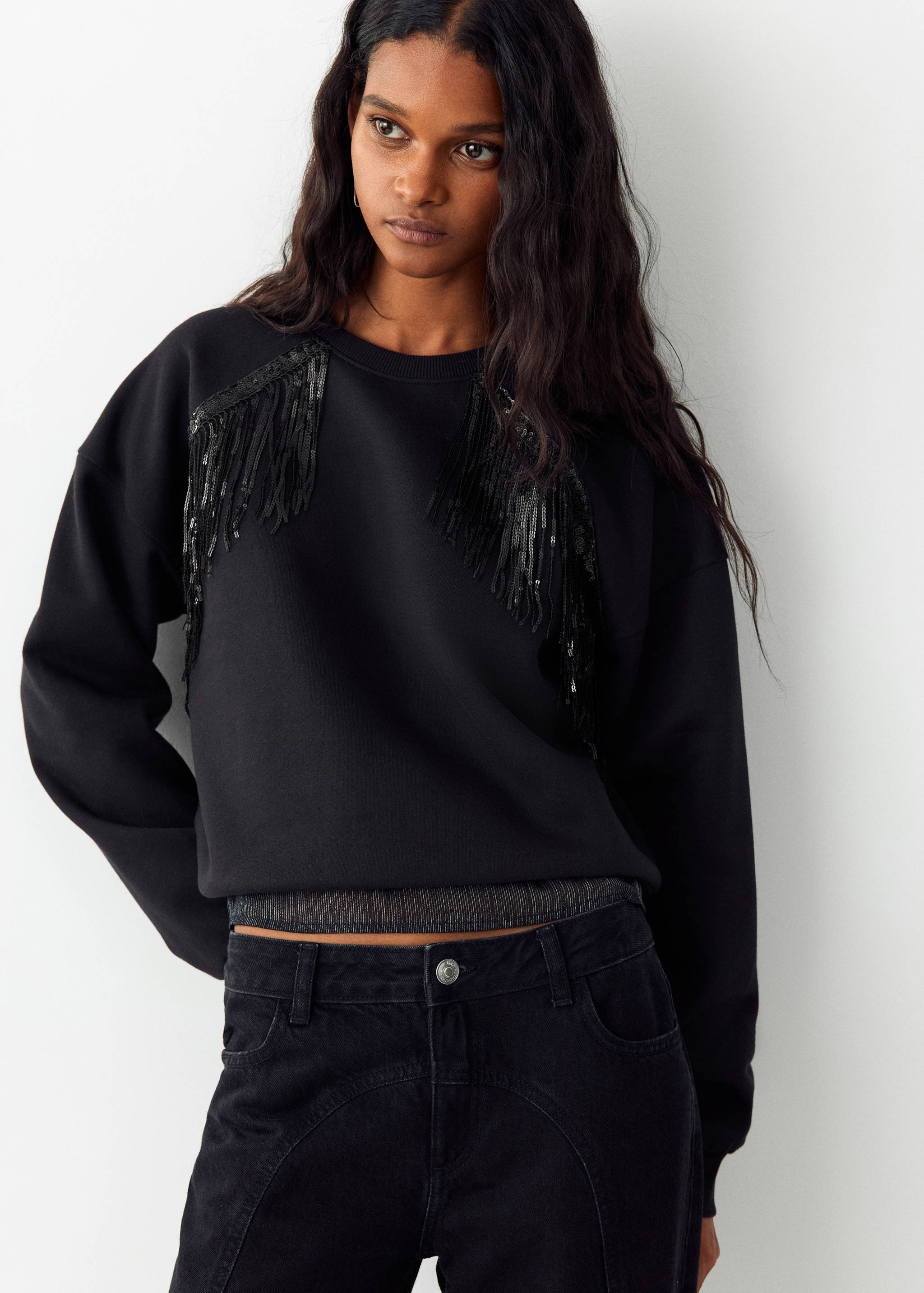 Black crew neck sweatshirt with sequin shoulder fringe.
