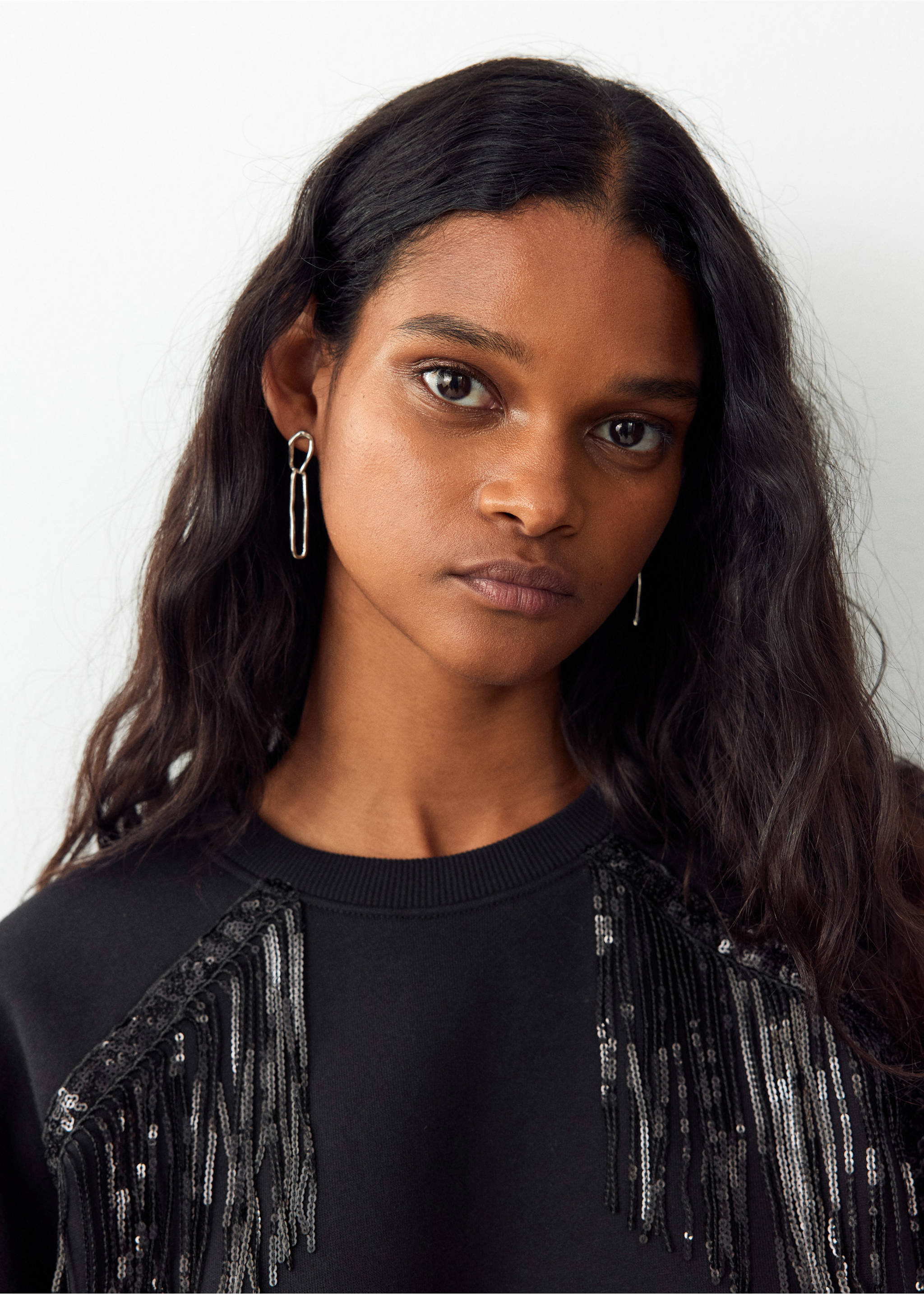 Black sweatshirt featuring sequin fringe shoulder detail in a close-up model view., Black. Ref: 37078636-00.
