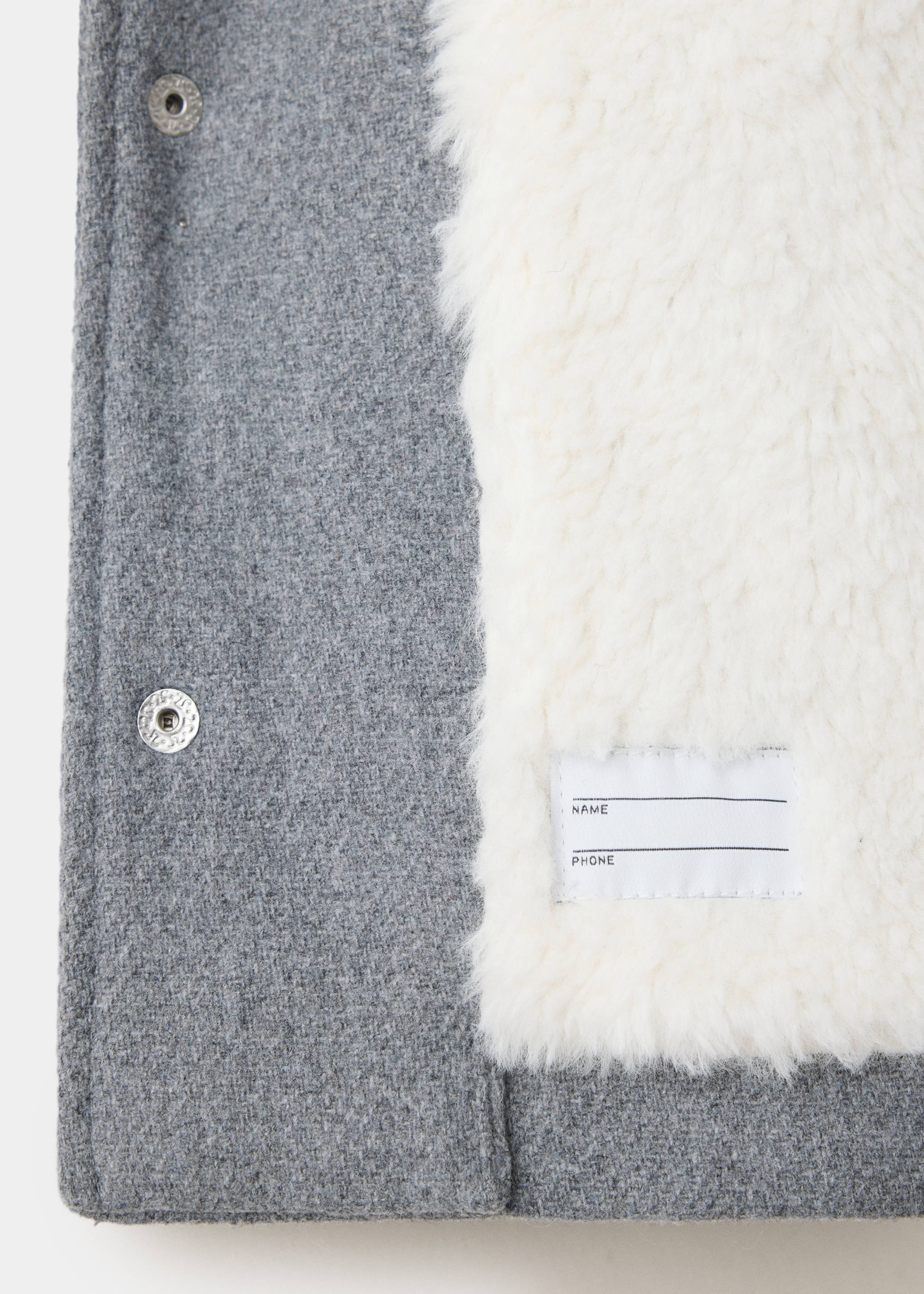Grey kids coat detail showing white faux-shearling lining