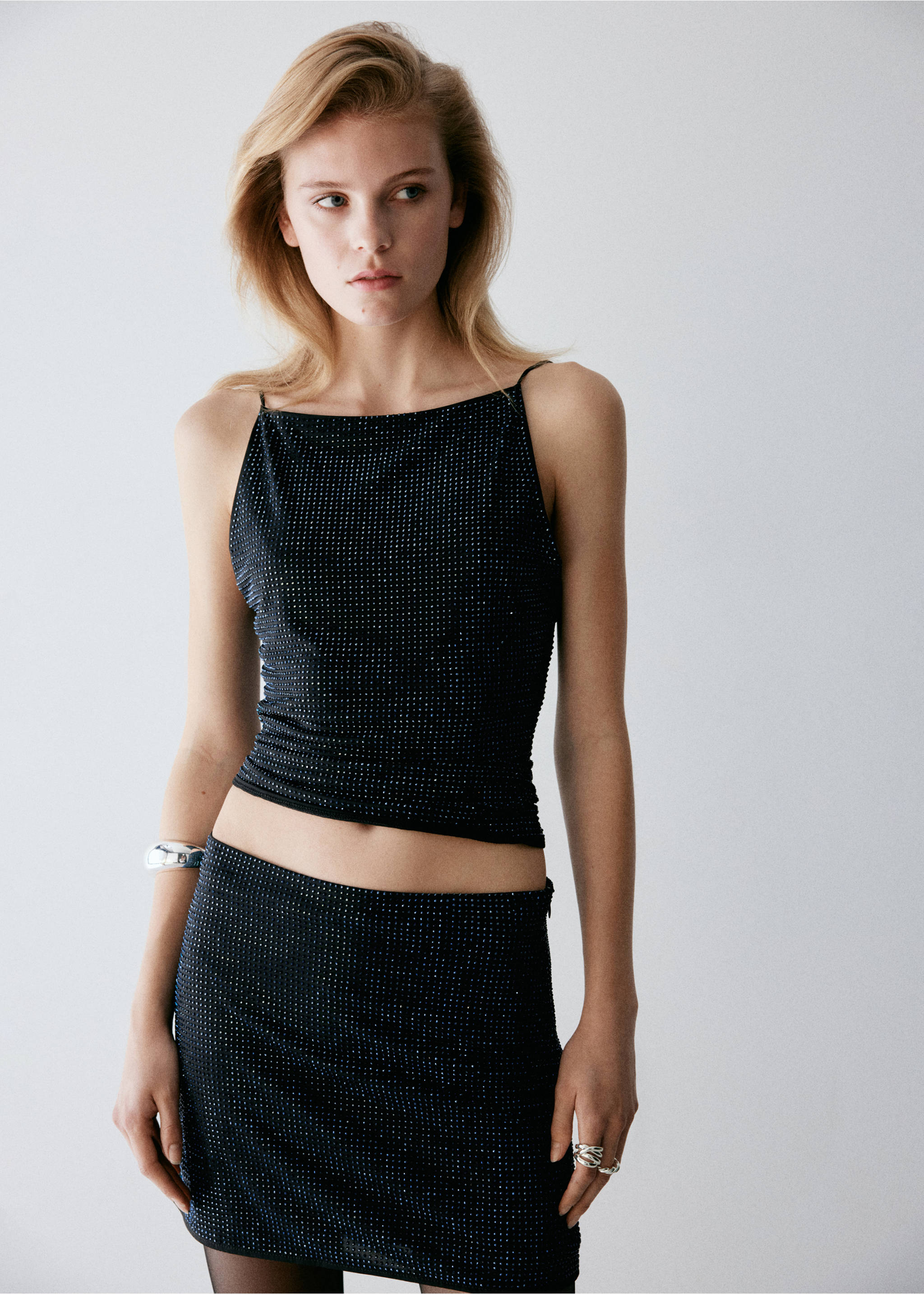 Black sparkly miniskirt with an iridescent grid pattern, worn as a matching set., Black. Ref: 37079118-00.