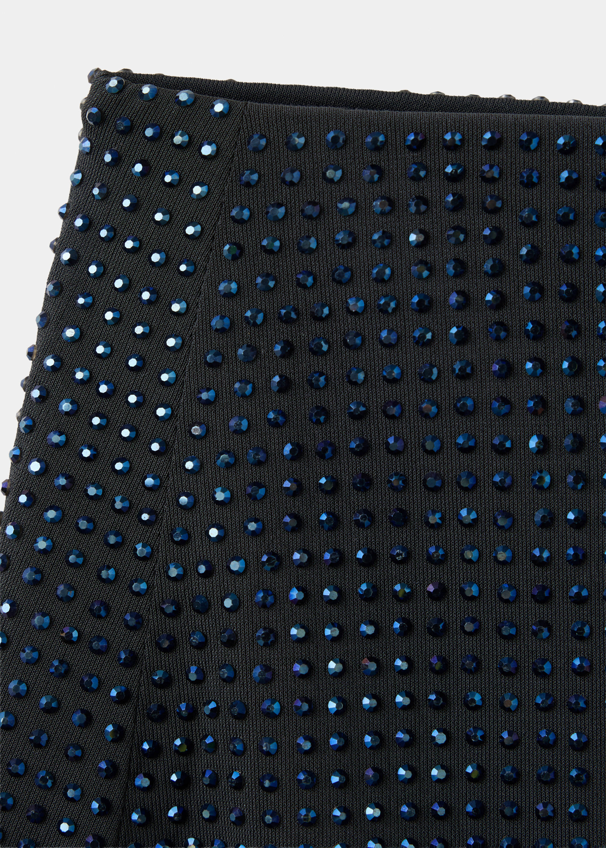 Close-up of a black skirt with blue rhinestone embellishments.