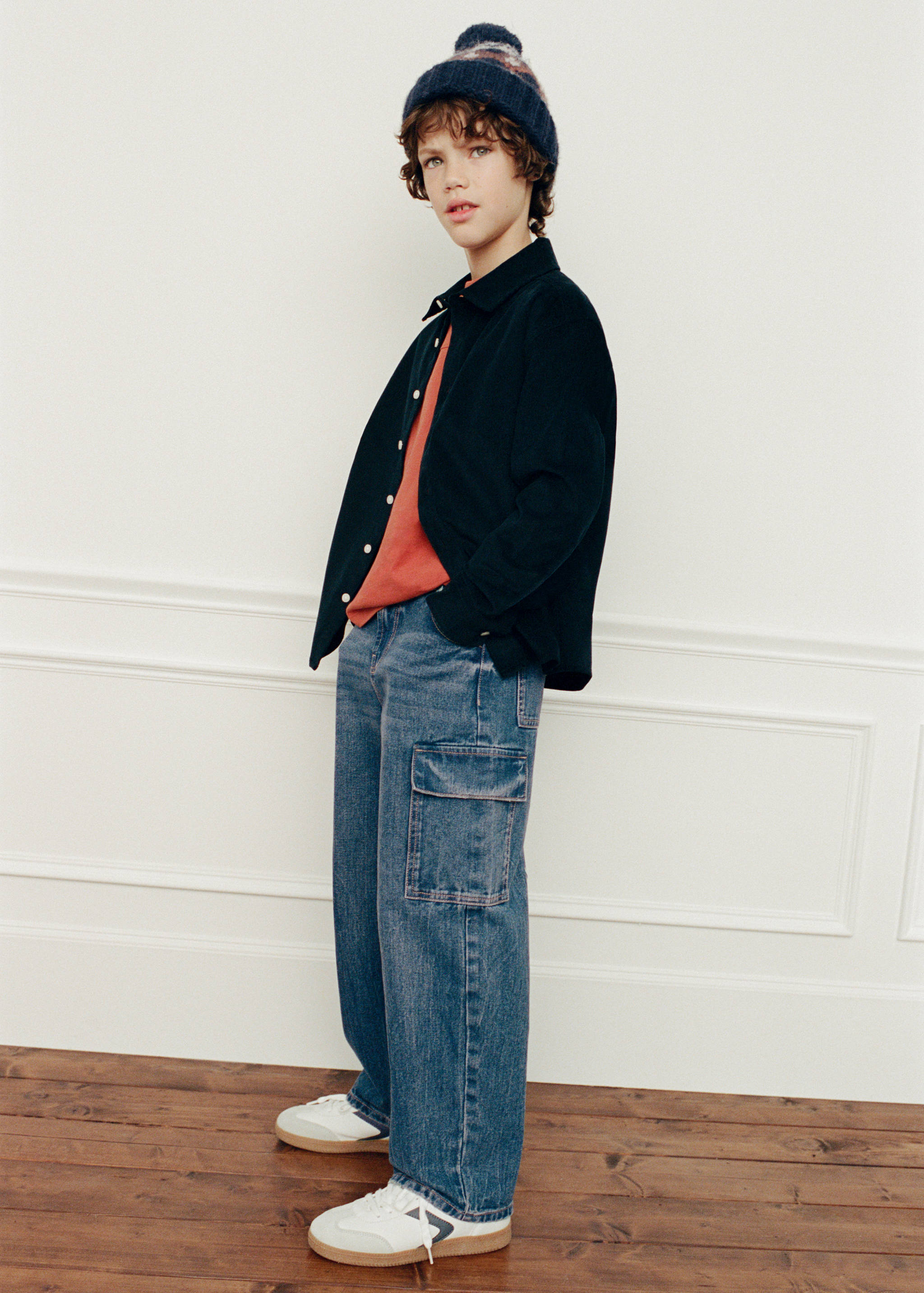 Pantalones cargo vaqueros de color azul combinados con camiseta y sobrecamisa naranjas.