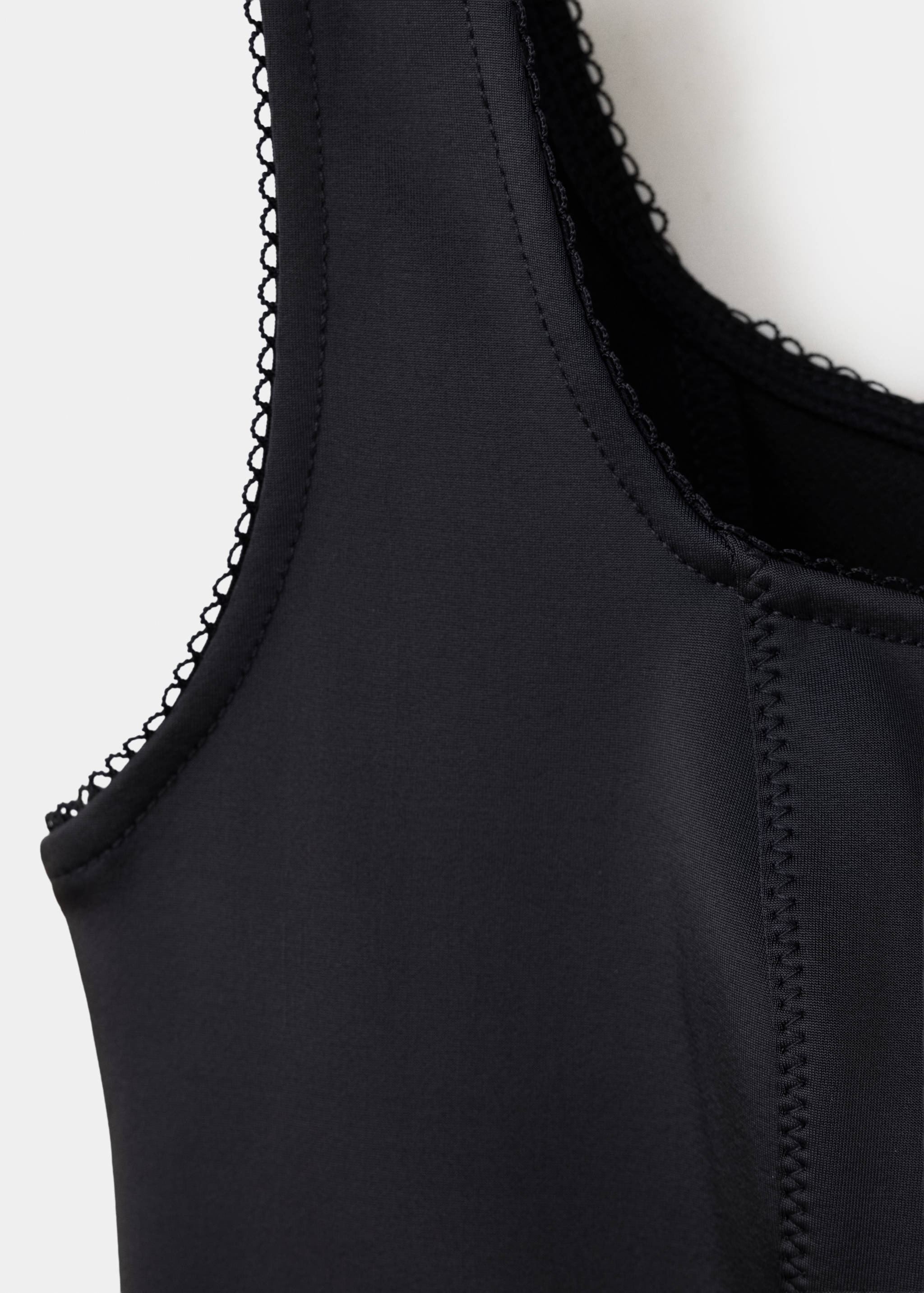 Black waistcoat detail showing the square neckline with lace trim.