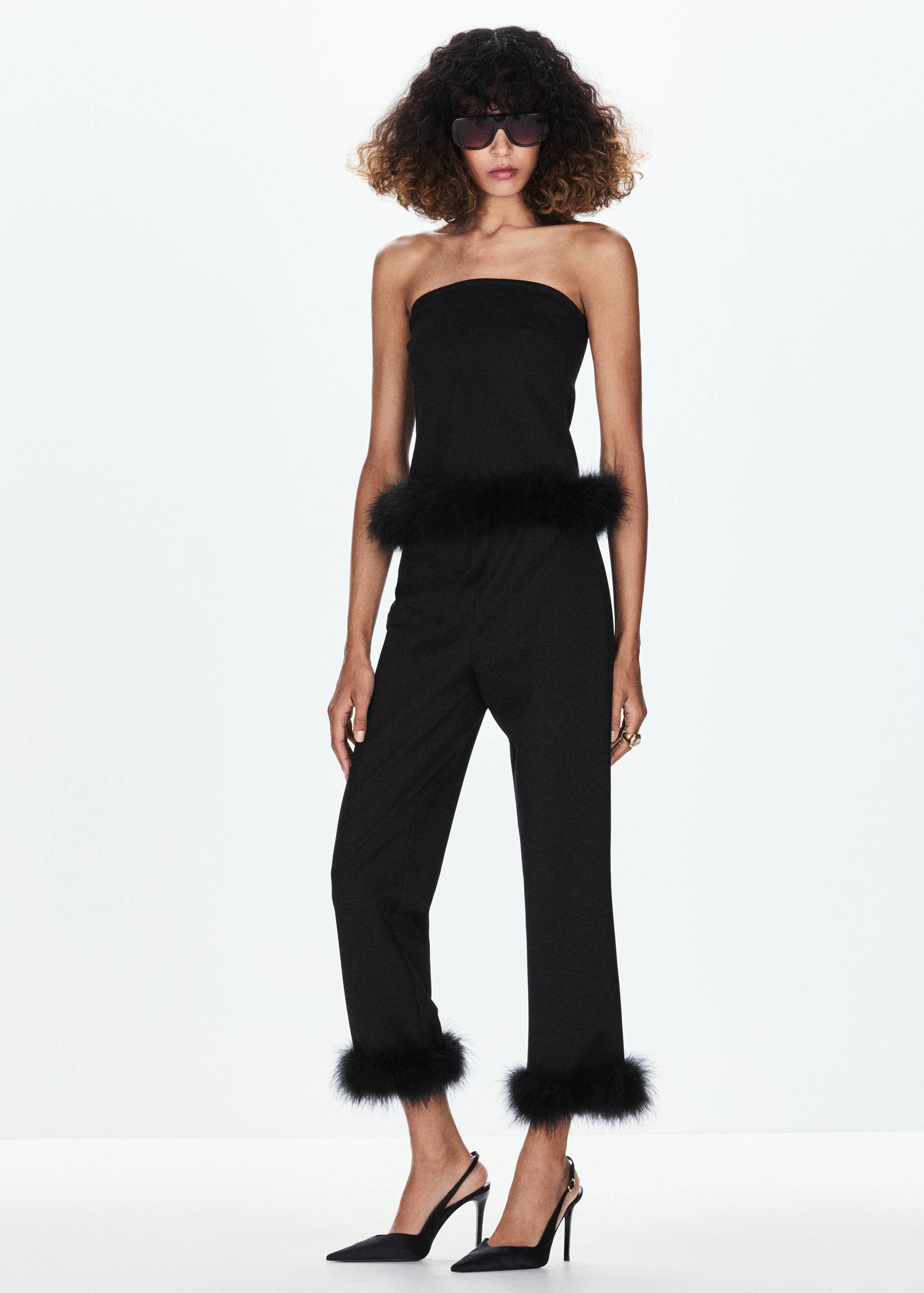 Black trousers with faux-fur cuffs, worn with a matching strapless top.