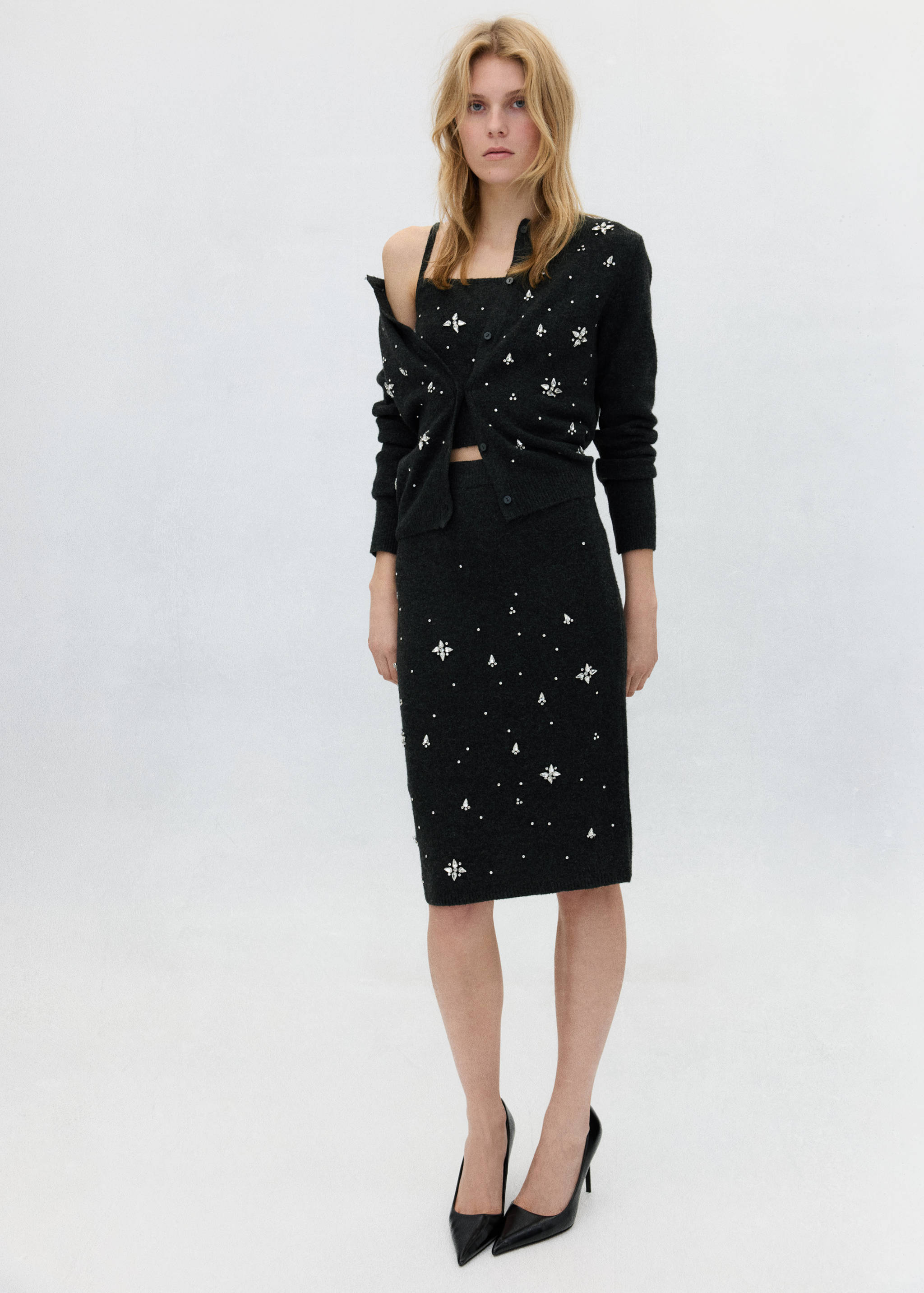 Dark grey embellished midi skirt worn with a matching top and cardigan.