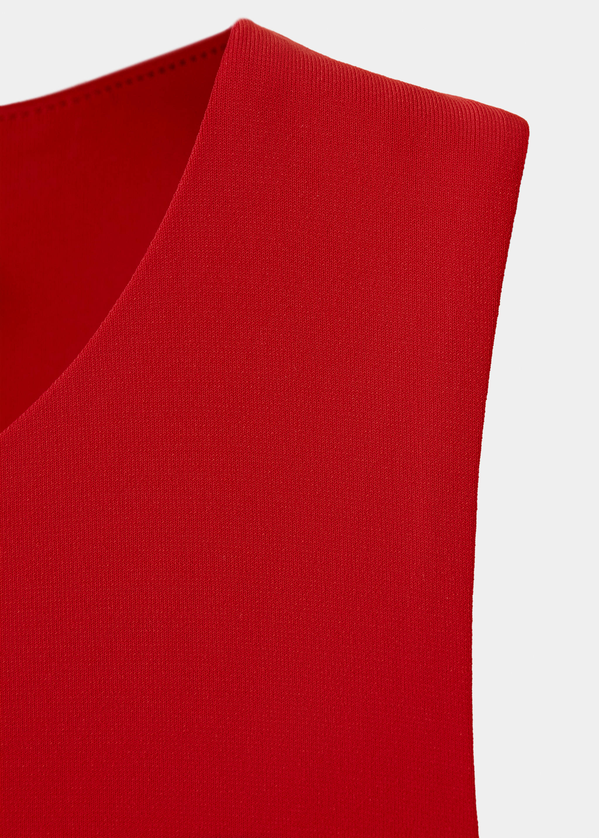 Red dress detail showing the sleeveless shoulder strap and neckline.