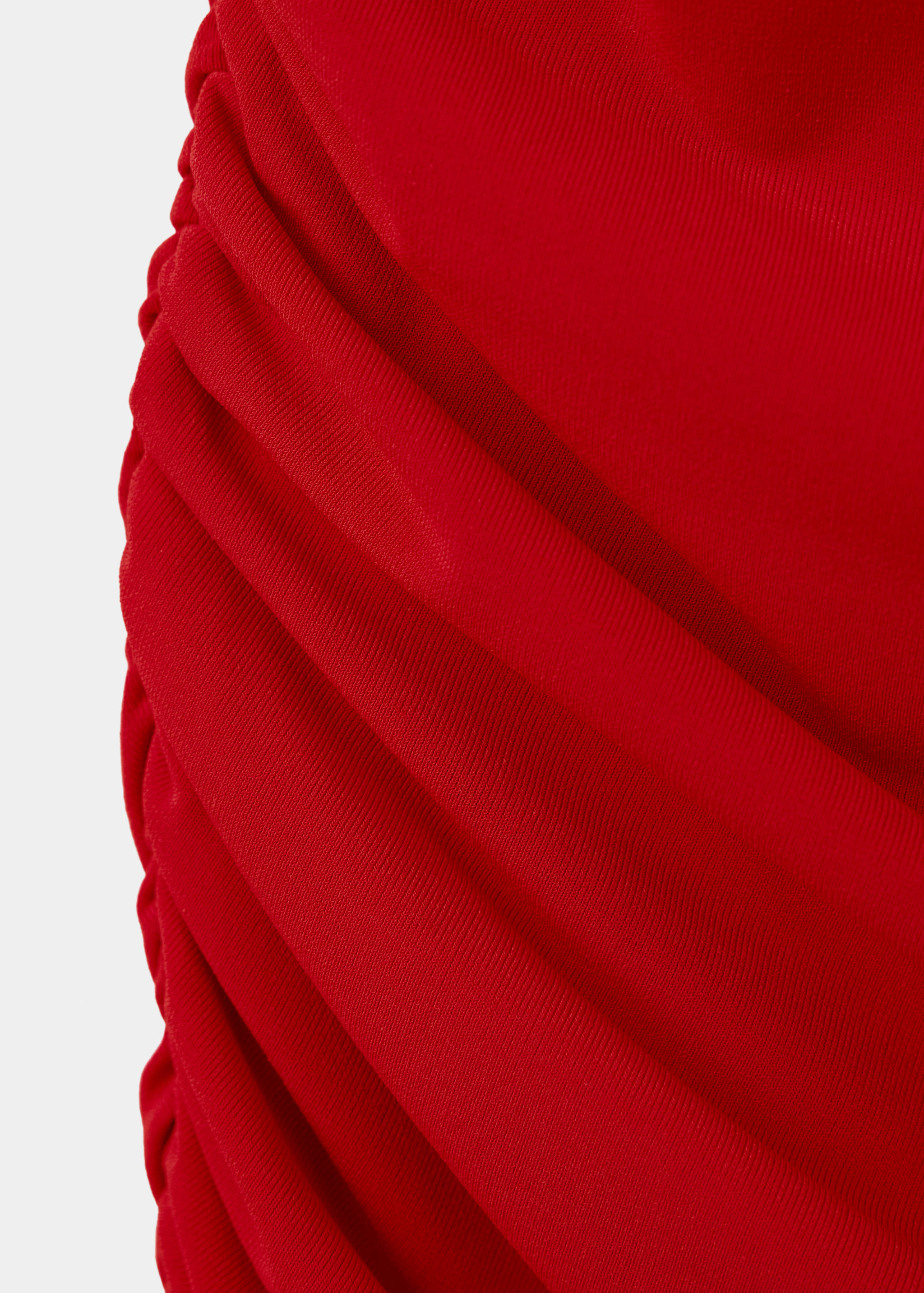 Close-up of red dress fabric with ruched texture.
